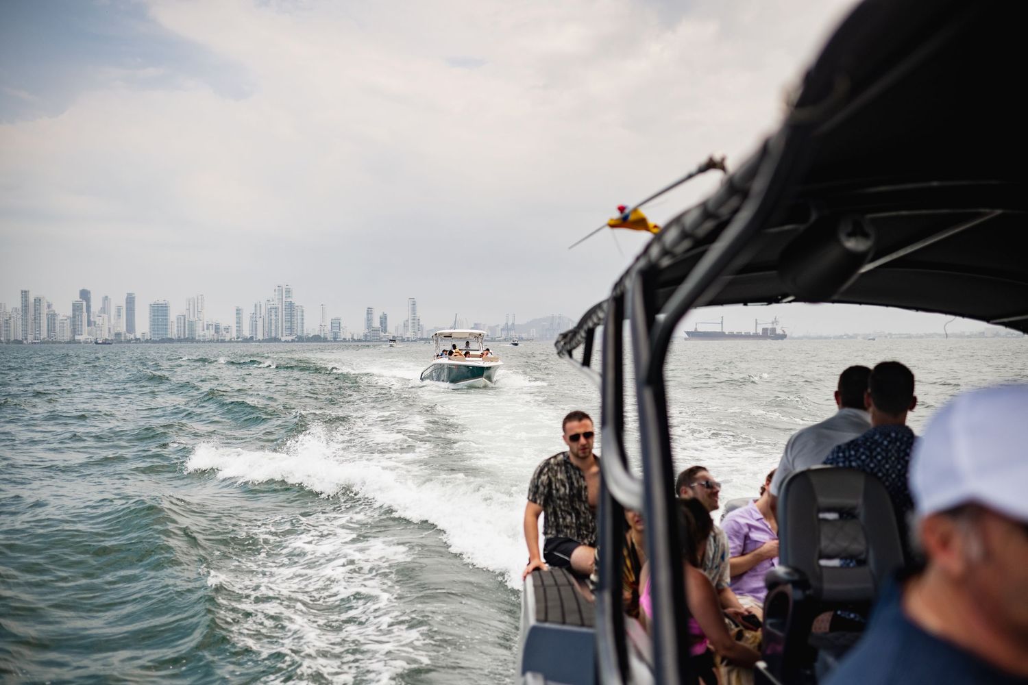 Aerial view of boats navigating through choppy ocean waters near Cartagena, Colombia on the horizon.