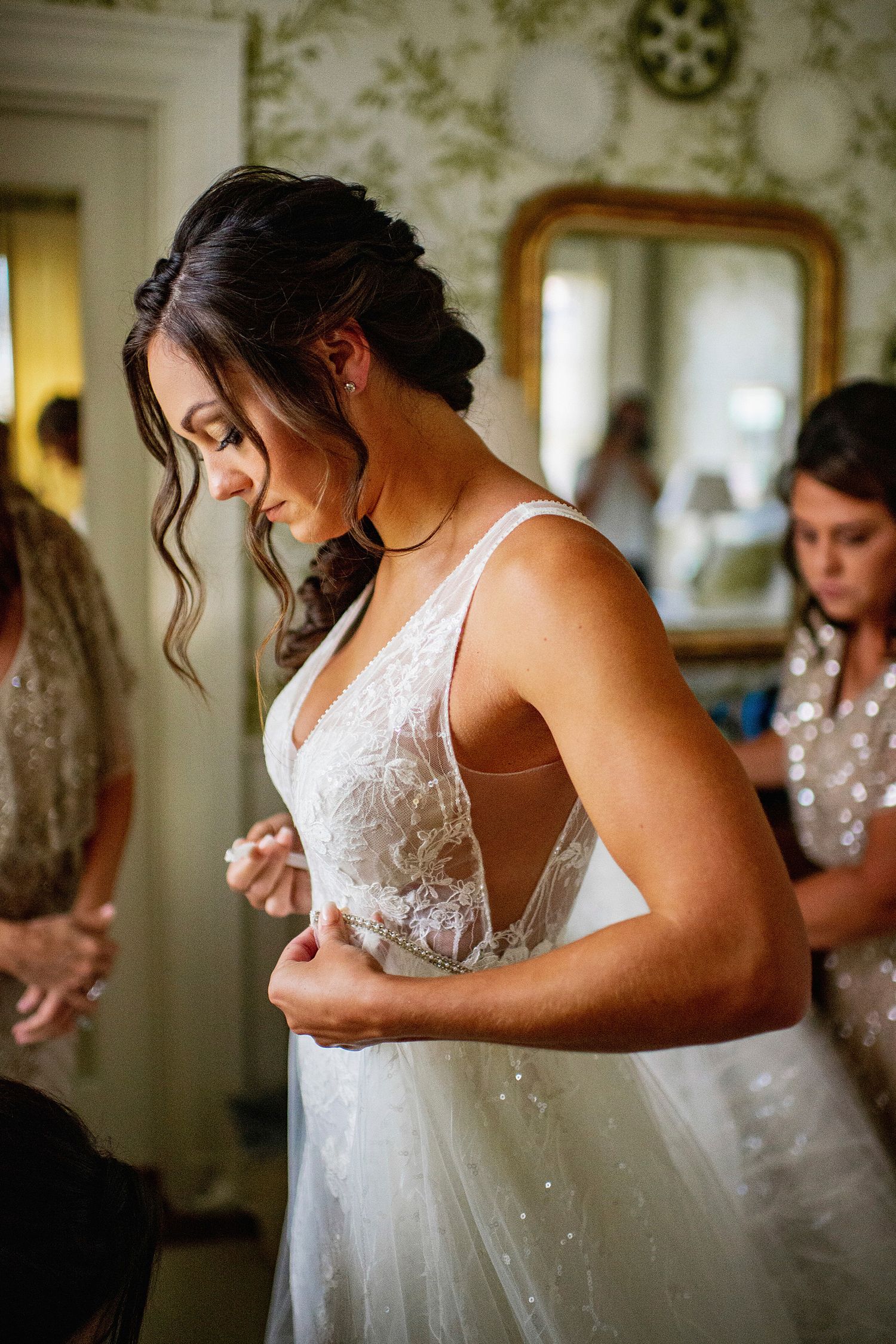 A bride adjusts her wedding dress during final preparations.
