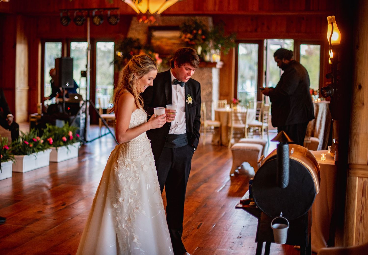 A romantic wedding reception scene with warm lighting and wooden floors in an elegant indoor venue.