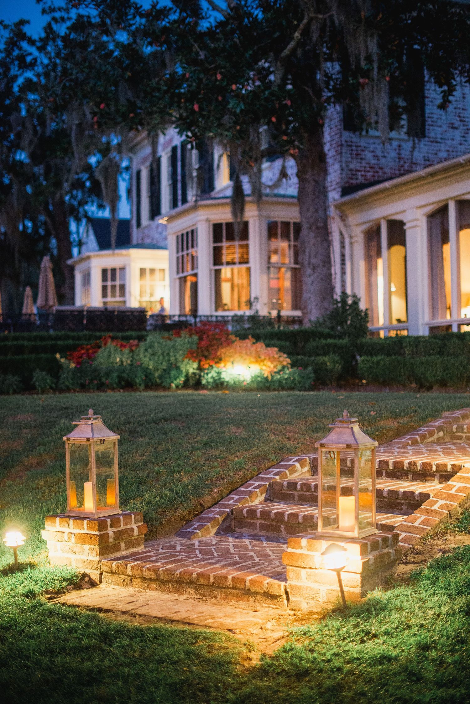 Illuminated stone steps with glowing lanterns create an enchanting garden pathway at dusk.