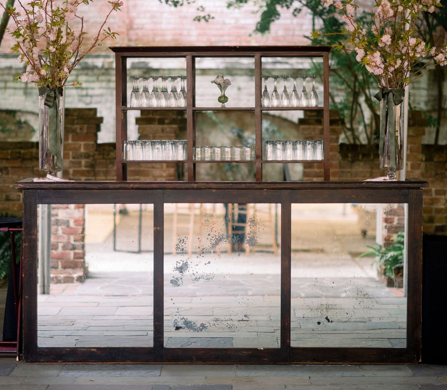 A rustic brick wall with large glass windows and metal framing creates an industrial architectural aesthetic.