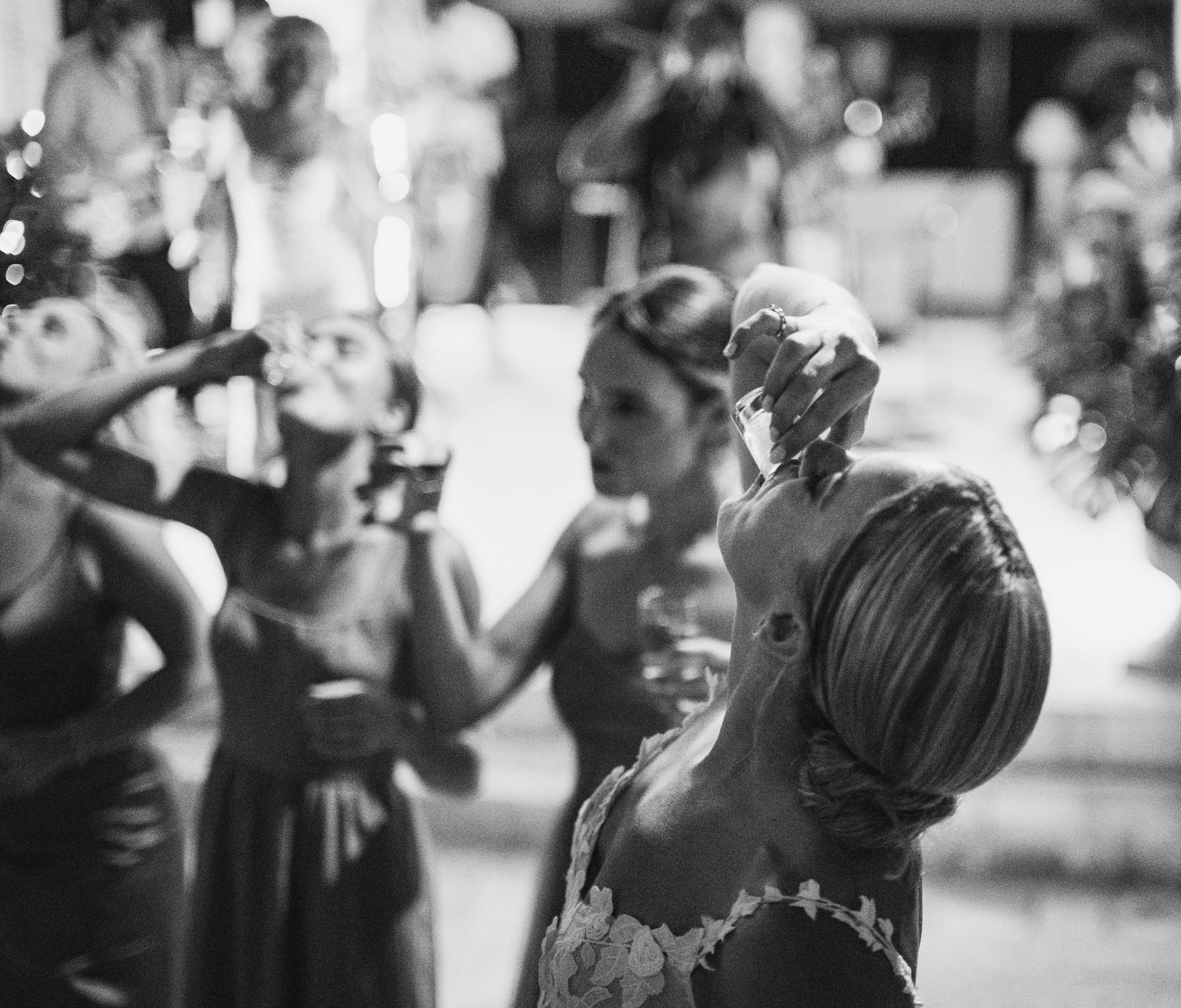 Black and white candid shots of wedding reception guests dancing and celebrating.