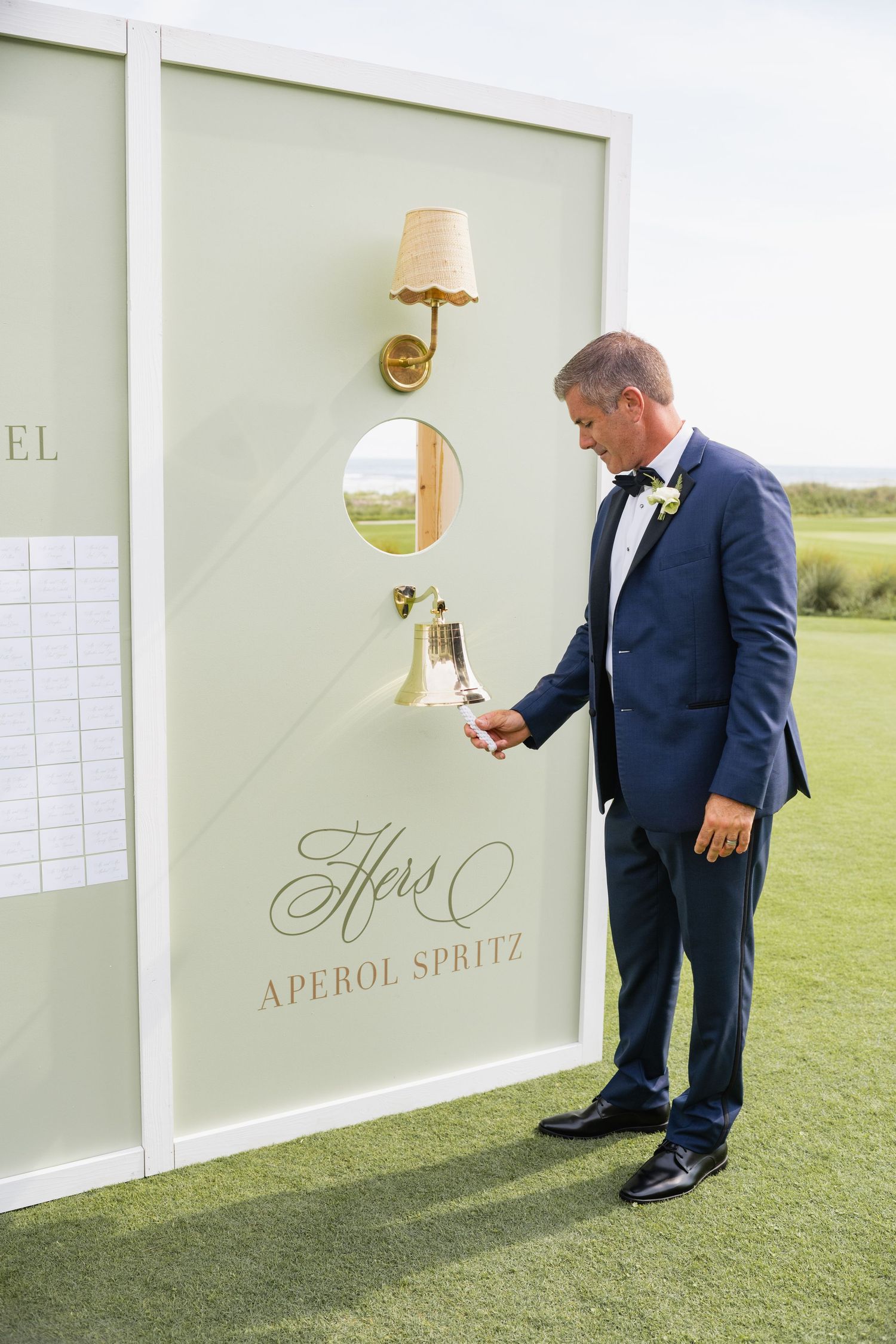 Wedding reception sign display with menu items on white panels against grass backdrop.
