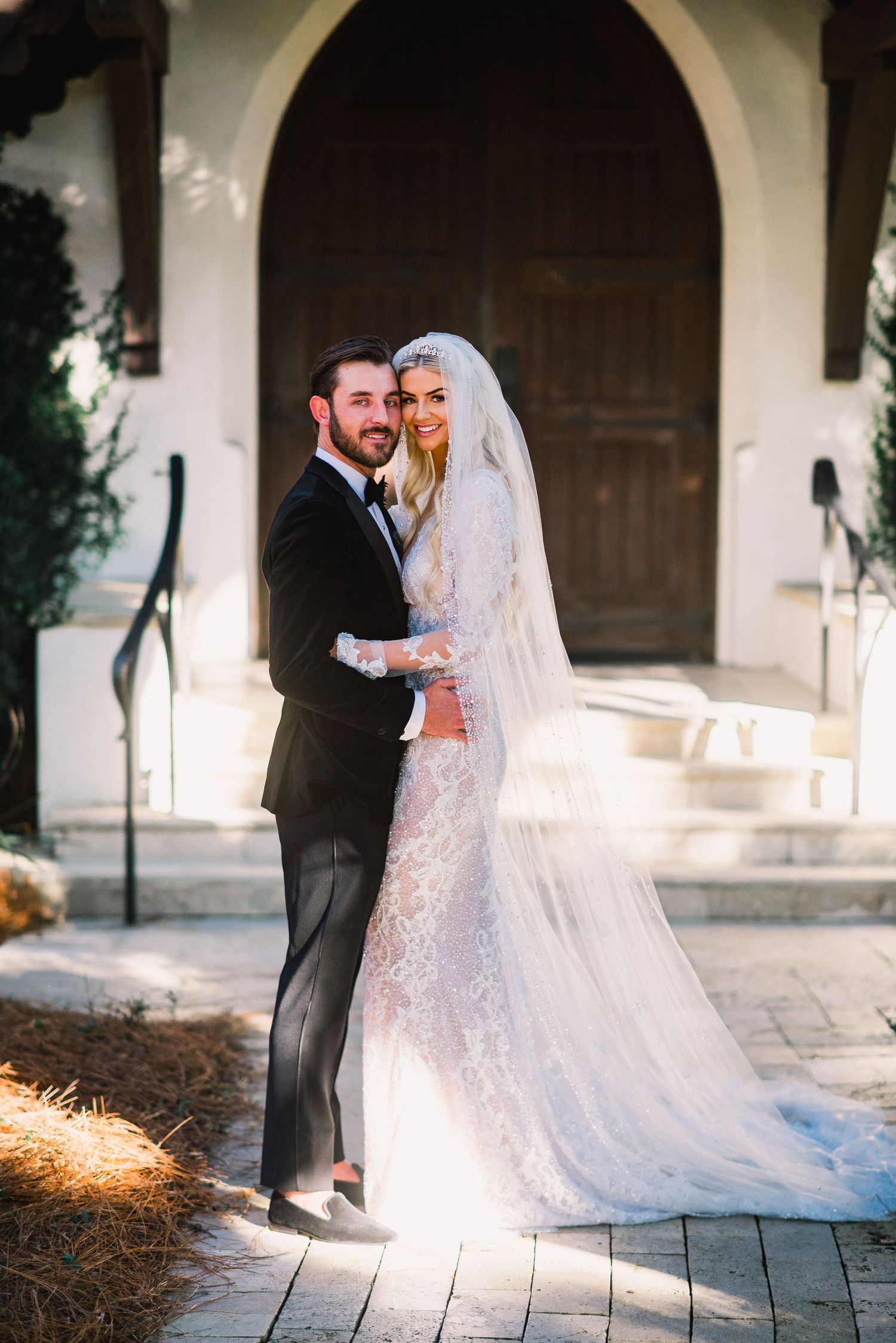 A bride and groom share romantic moments together during their winter wedding photo session at a rustic venue.
