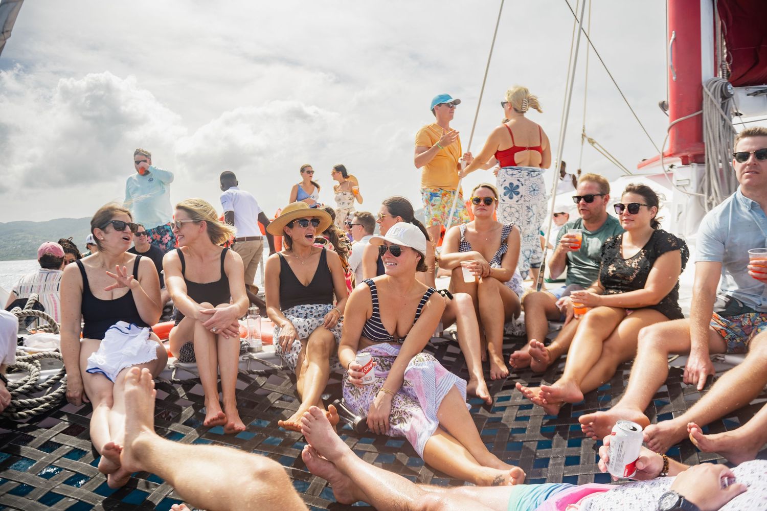 A group of people relaxing and sunbathing on a beach during a sunny summer day.