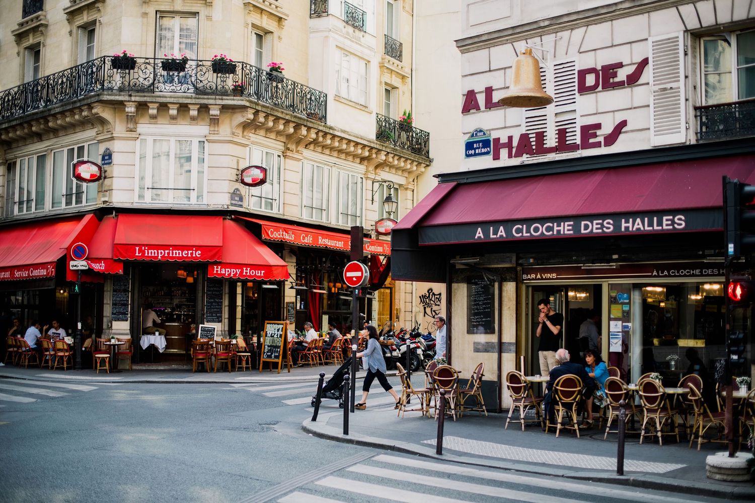 Historic Parisian street corner with classic architecture and cafe awnings.