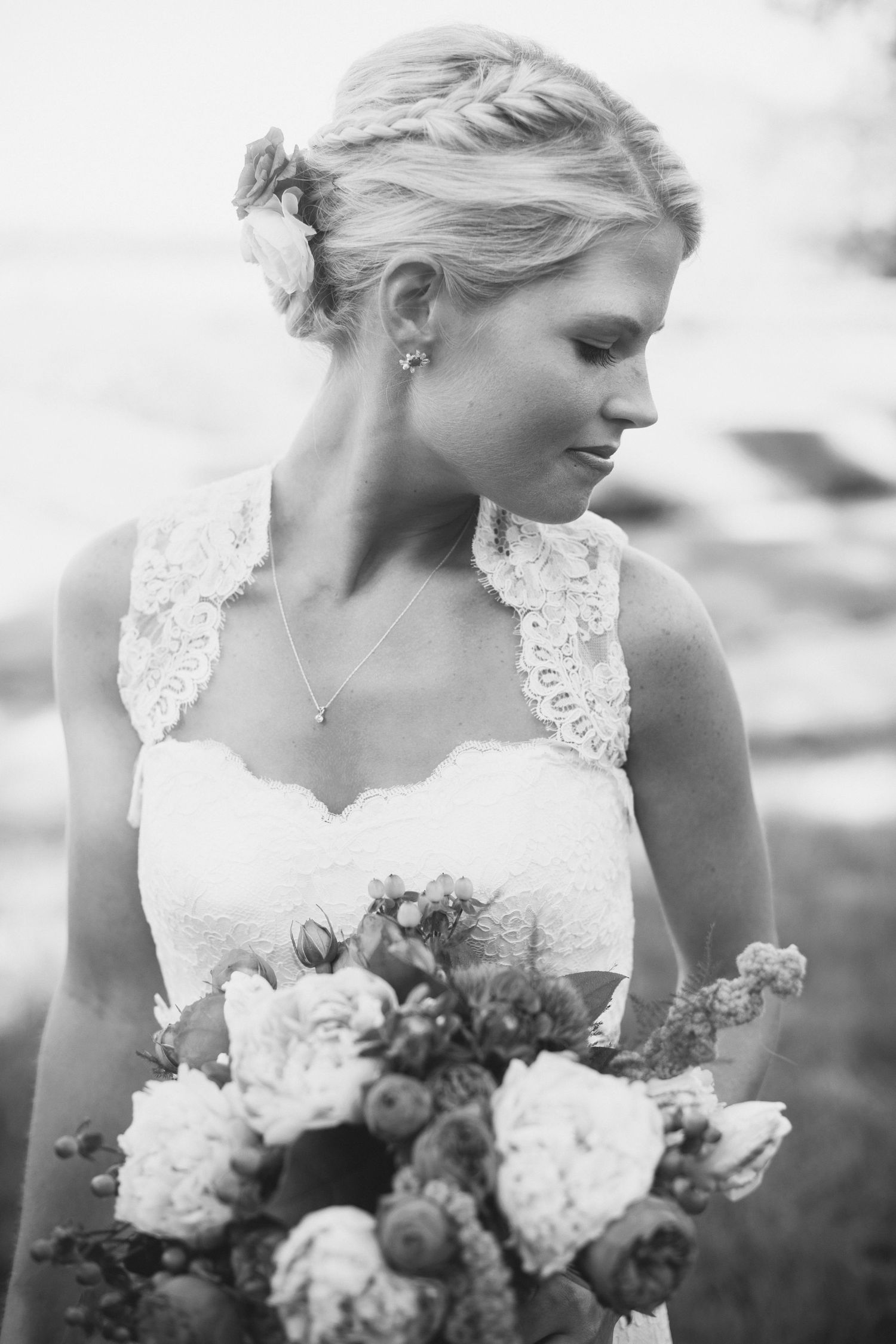 Black and white series of a bride in lace dress holding a white and blush floral bouquet.
