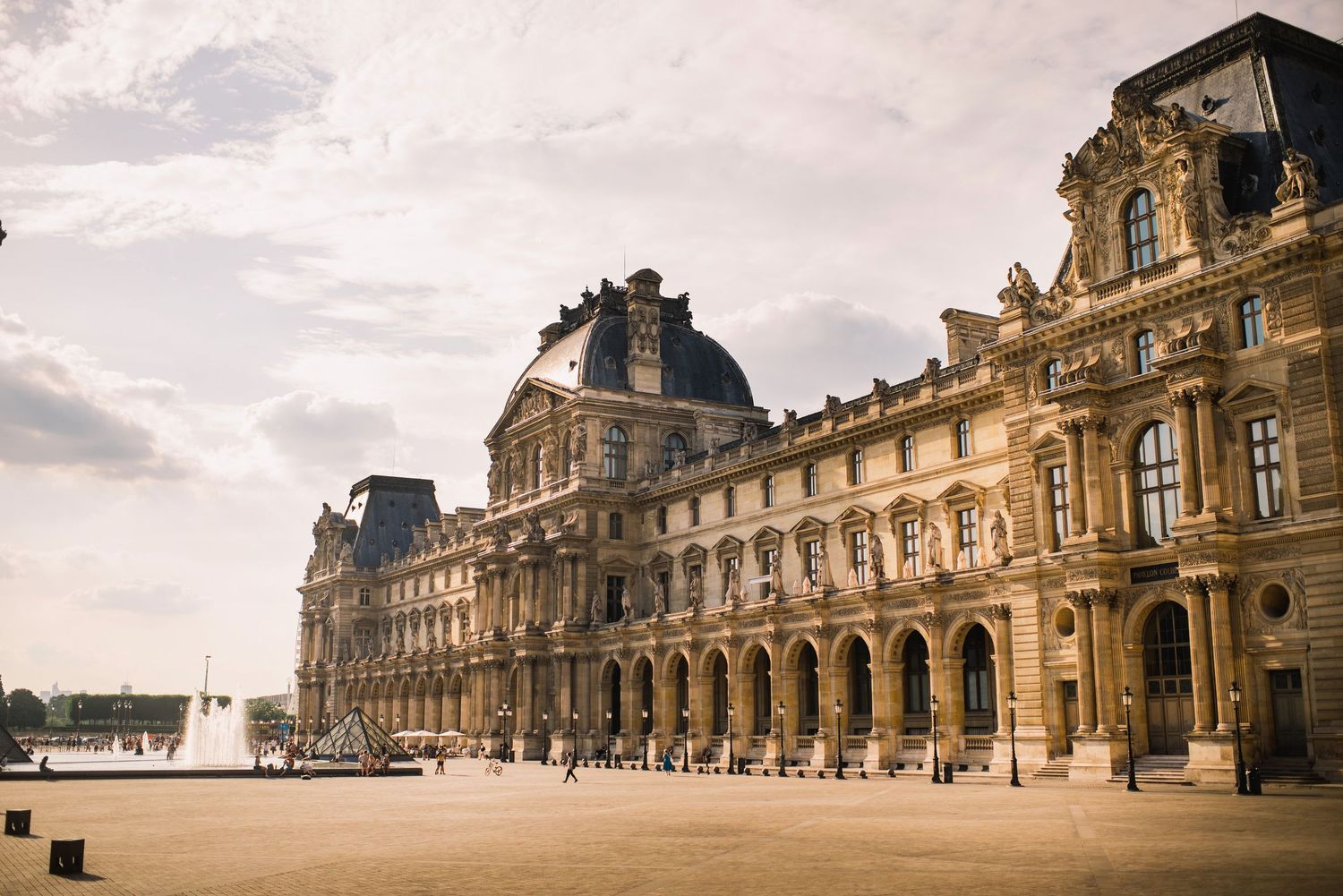 Panoramic view of the grand Louvre Museum facade with its iconic classical architecture.
