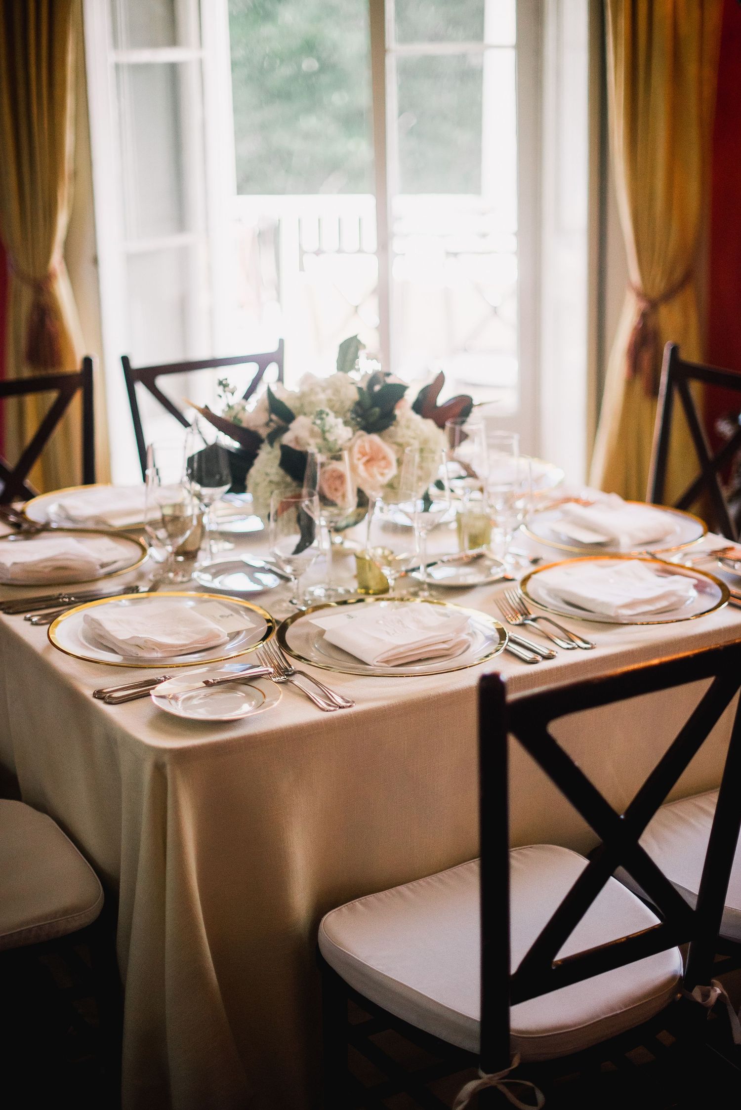 Elegant table settings with white linens, silverware, and place settings arranged for a formal dining event.