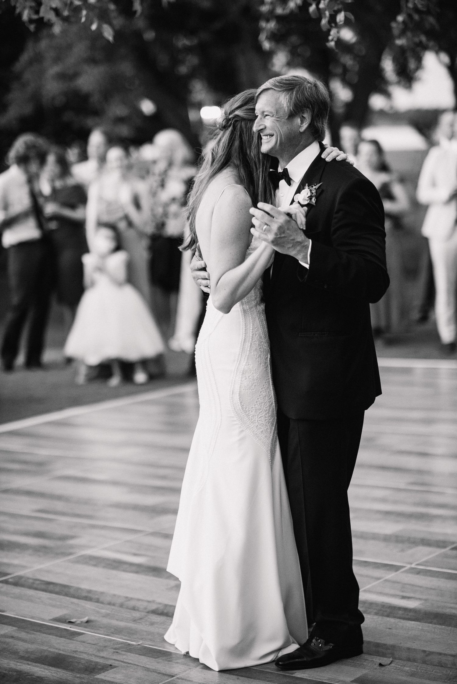 A tender moment captured in black and white as a couple shares their first dance at a wedding reception.
