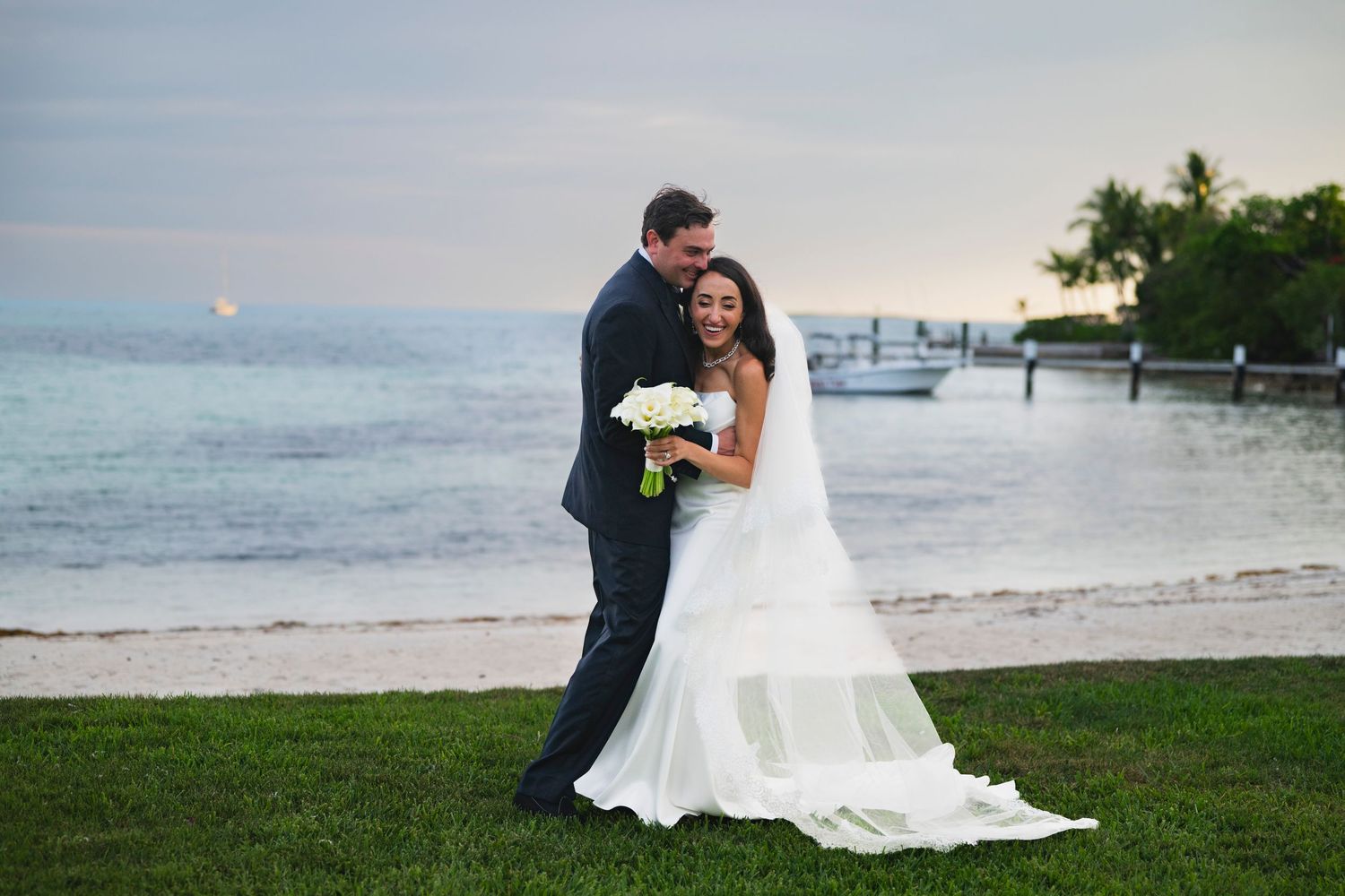 A romantic beach wedding photoshoot featuring a couple on a scenic shoreline at sunset.
