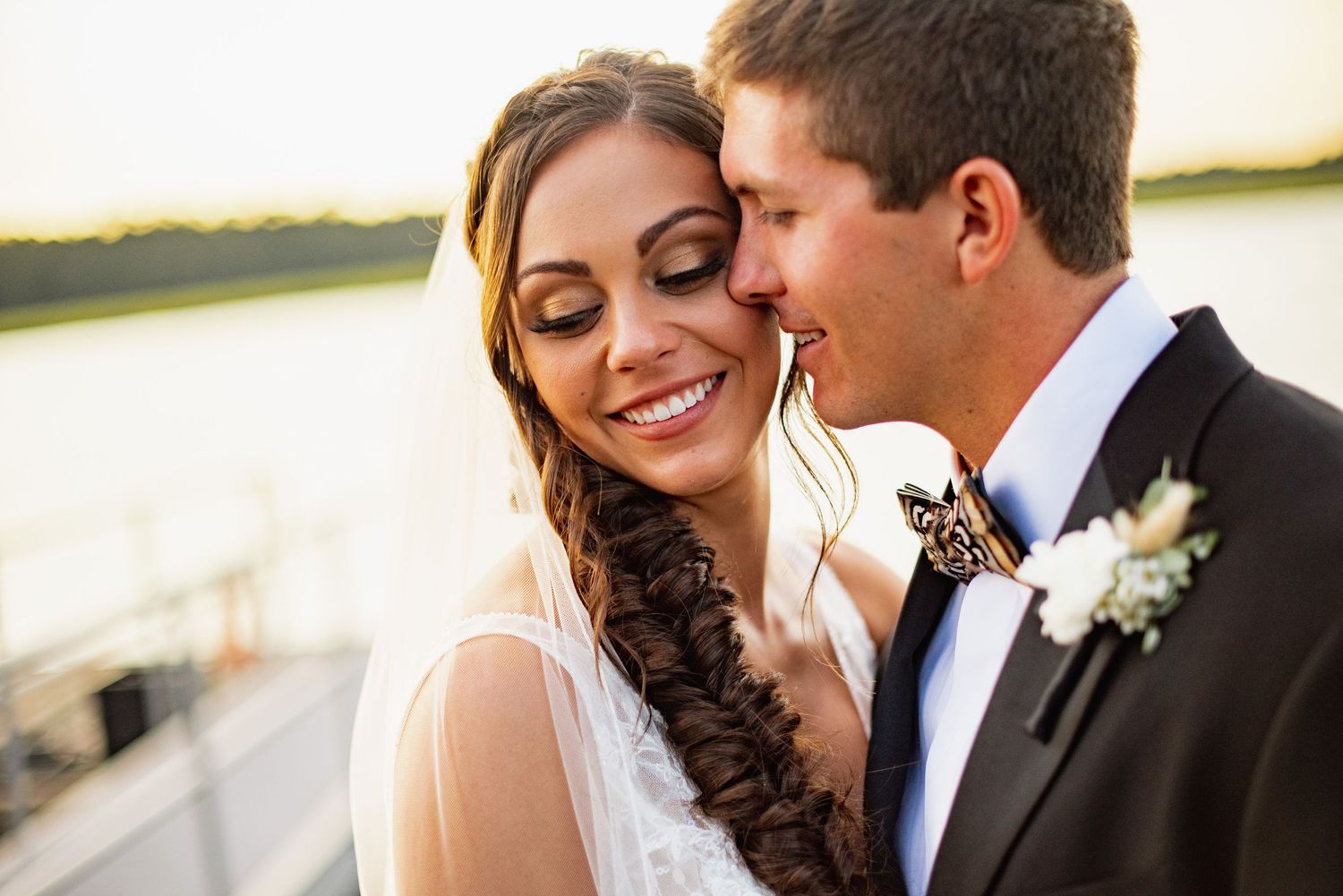 A romantic wedding couple shares intimate moments in a series of outdoor portraits in natural lighting.