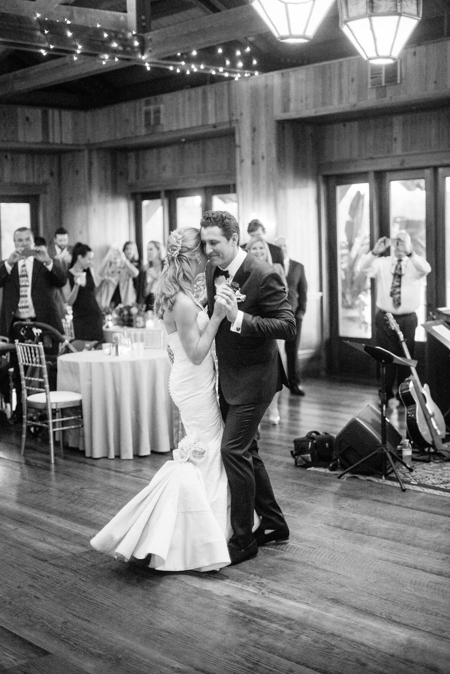 A series of black and white photos showing a couple dancing during their first dance at a wedding reception.