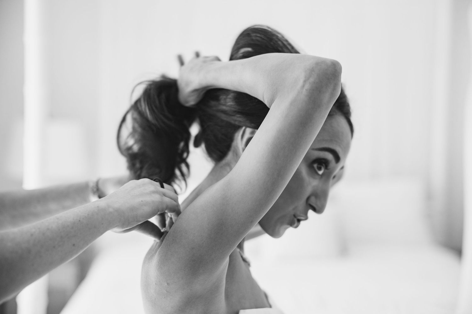 A series of black and white photos showing a person stretching and doing yoga poses in a bright room.