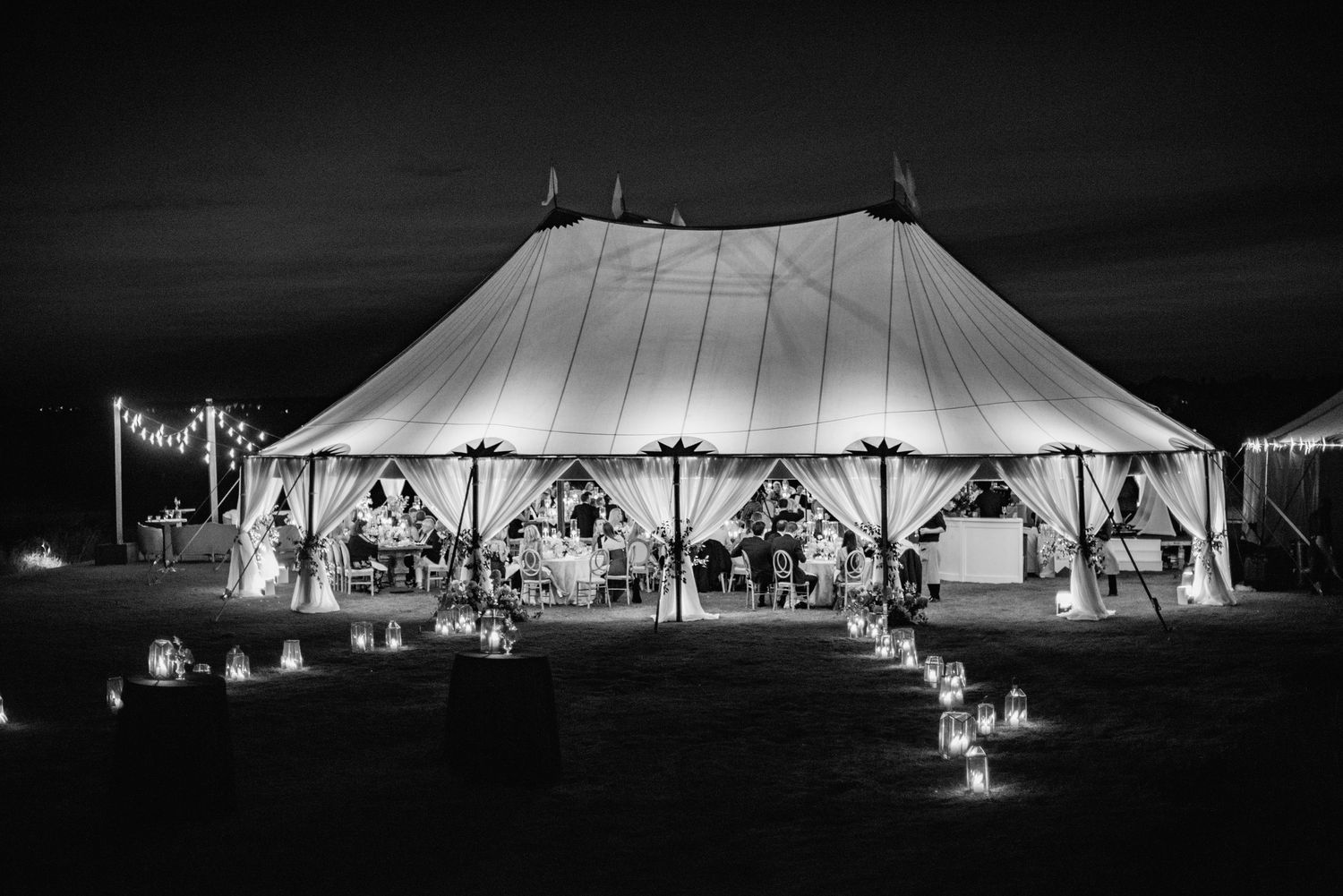 A series of black and white photos showing illuminated wedding tents at night creating a dramatic silhouette effect.