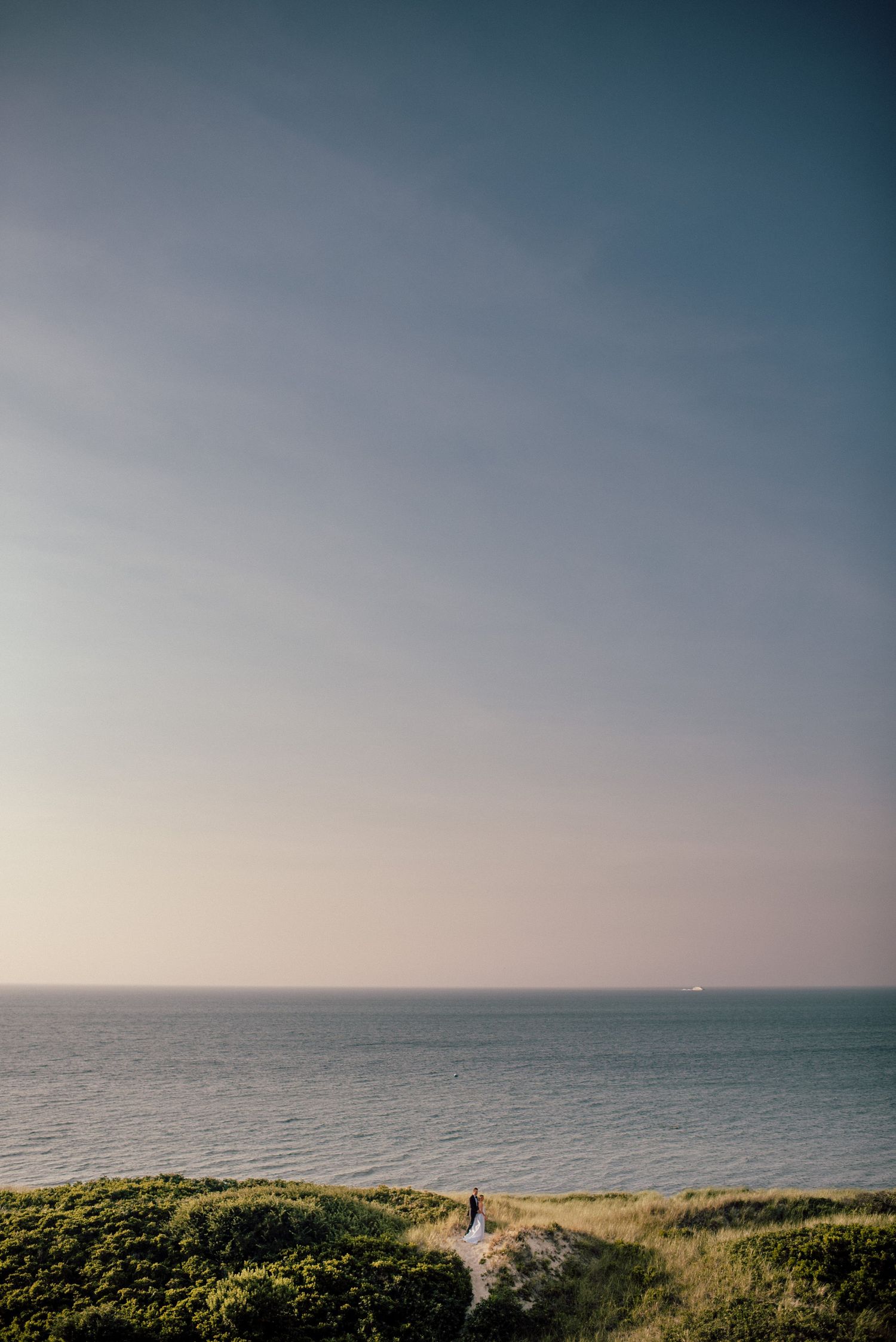 Scenic coastal landscape with rolling hills and ocean views under a blue sky.