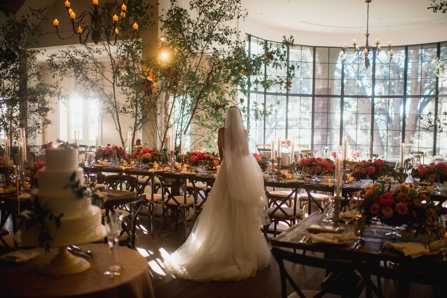 Elegant wedding reception venue decorated with twinkling lights, greenery, and white tablecloths for a romantic atmosphere.