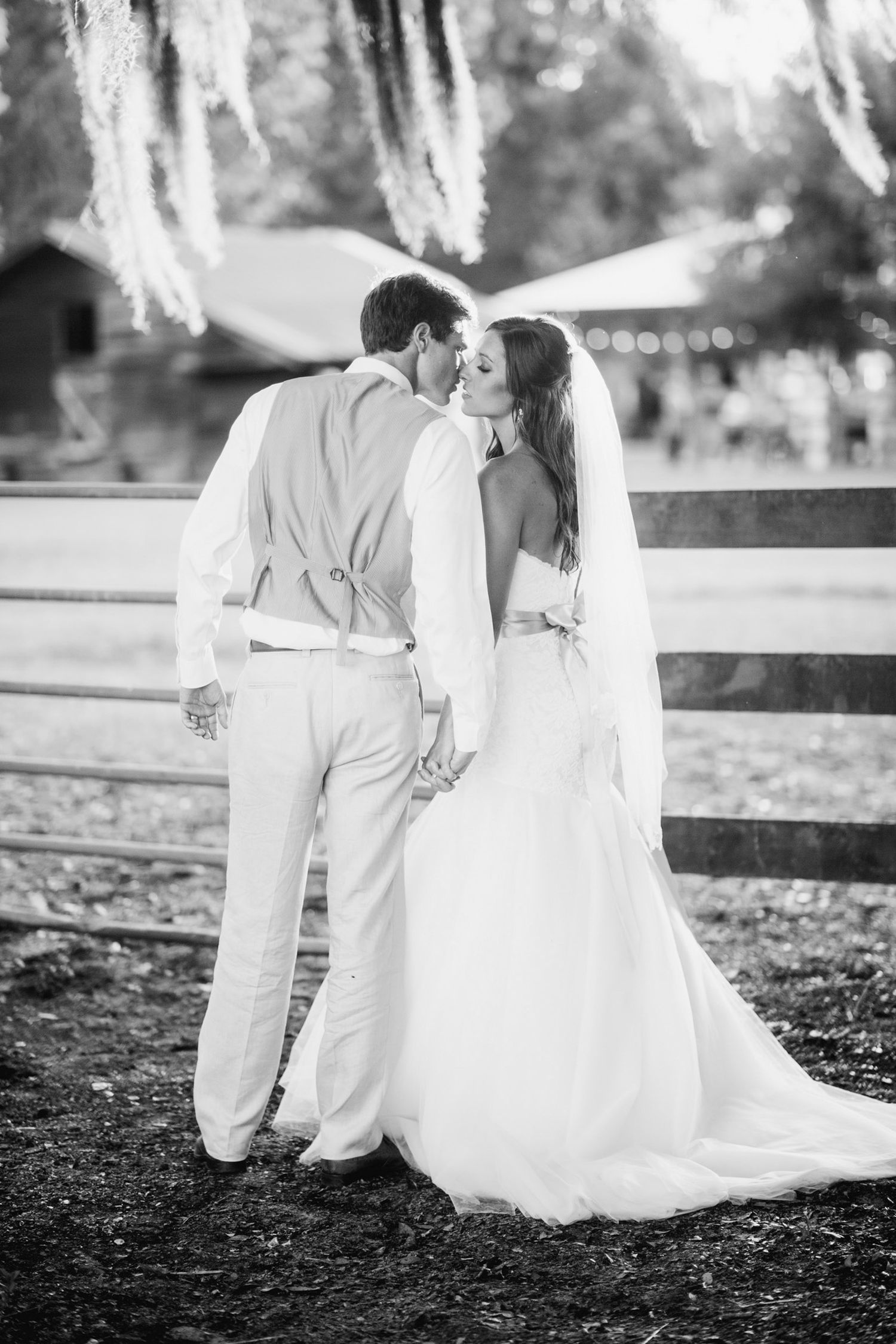 Black and white wedding photos capturing intimate moments between couple sitting on ground.
