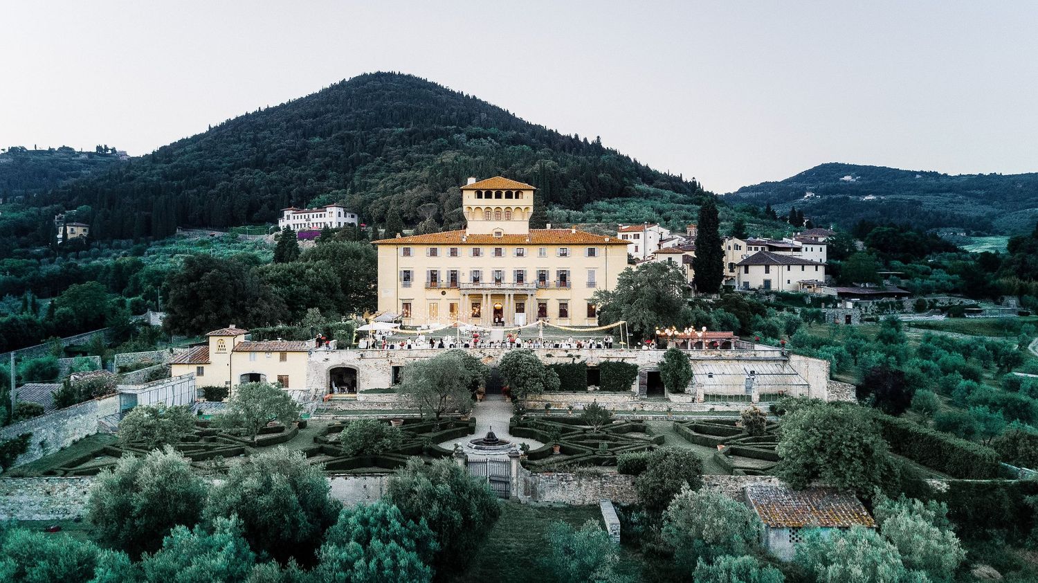 Panoramic view of Mediterranean hillside village with white buildings nestled among olive groves. Tuscany wedding in Italy