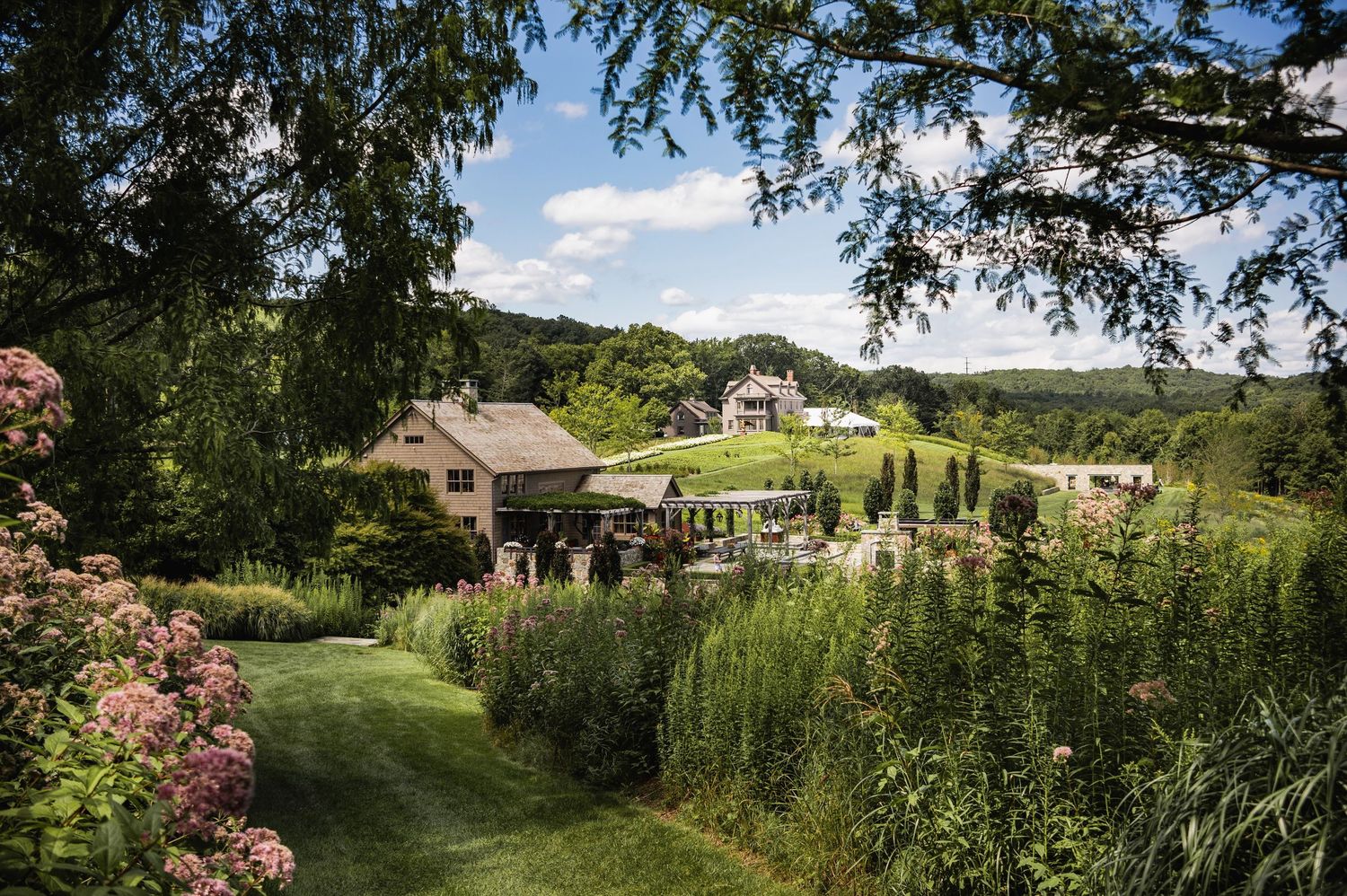 Scenic country estate in Connecticut with manicured gardens nestled among rolling green hills and trees.