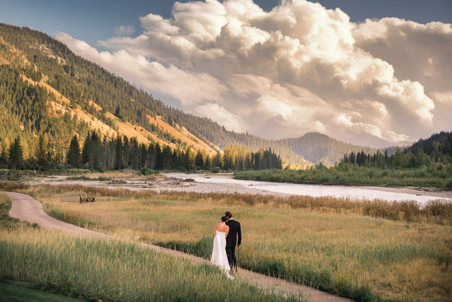 Panoramic mountain landscape with rolling meadows and dramatic clouds at sunset in Colorado.