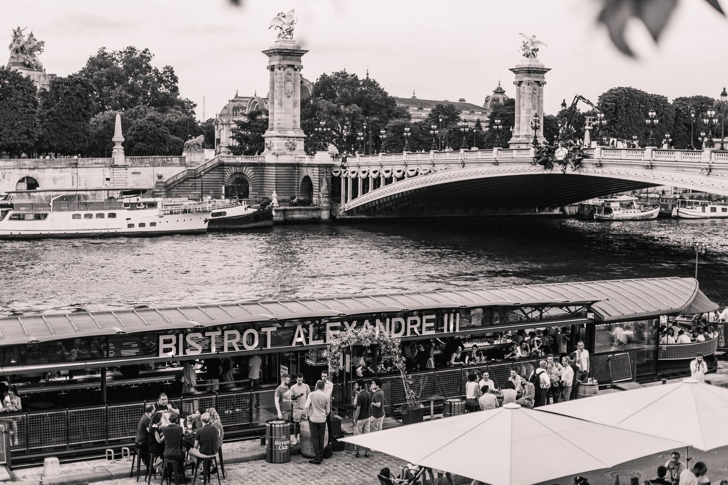 Vintage black and white panorama of a historic bridge and river in Paris France.