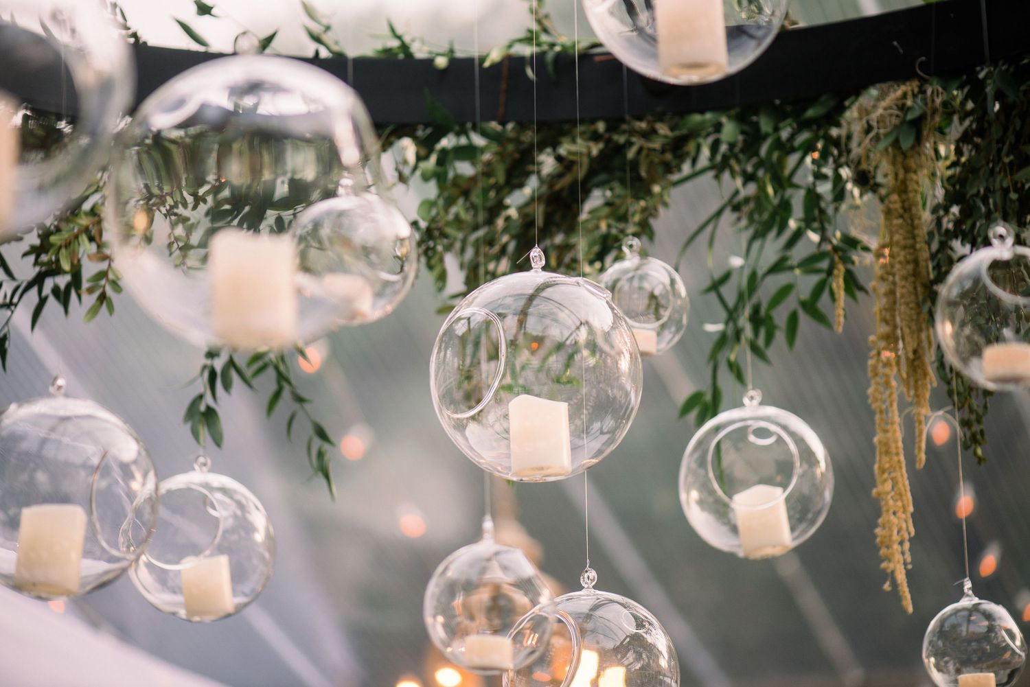 Glass orb decorations hanging from tree branches create a magical outdoor atmosphere.