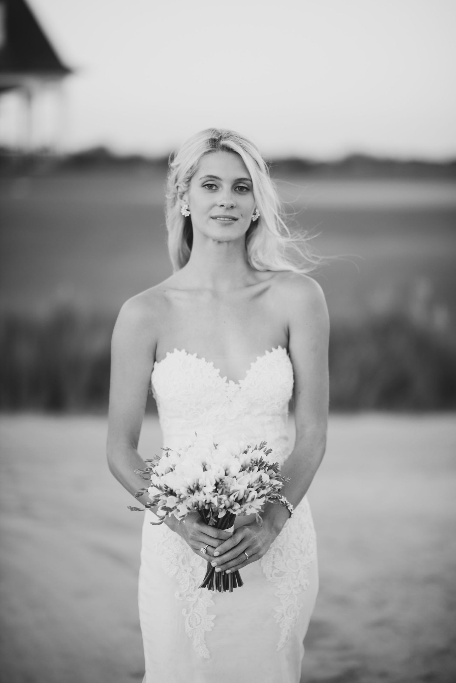 A black and white series of bridal portraits showing a strapless white wedding dress and bouquet in an outdoor setting.