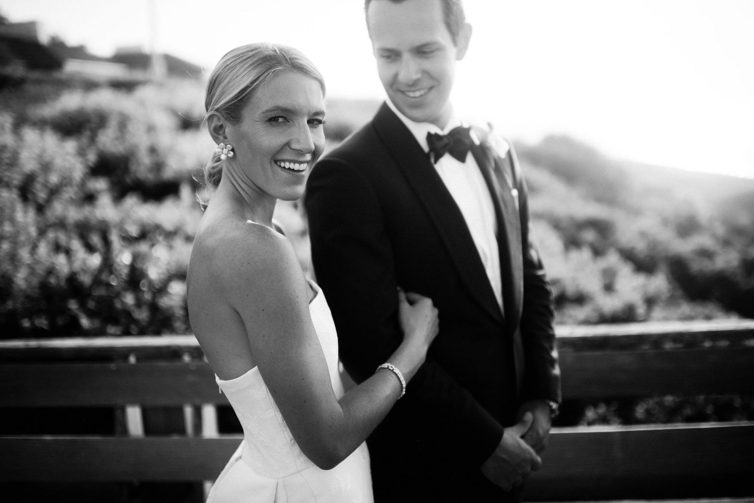 Black and white candid moments of newlyweds laughing together outdoors.