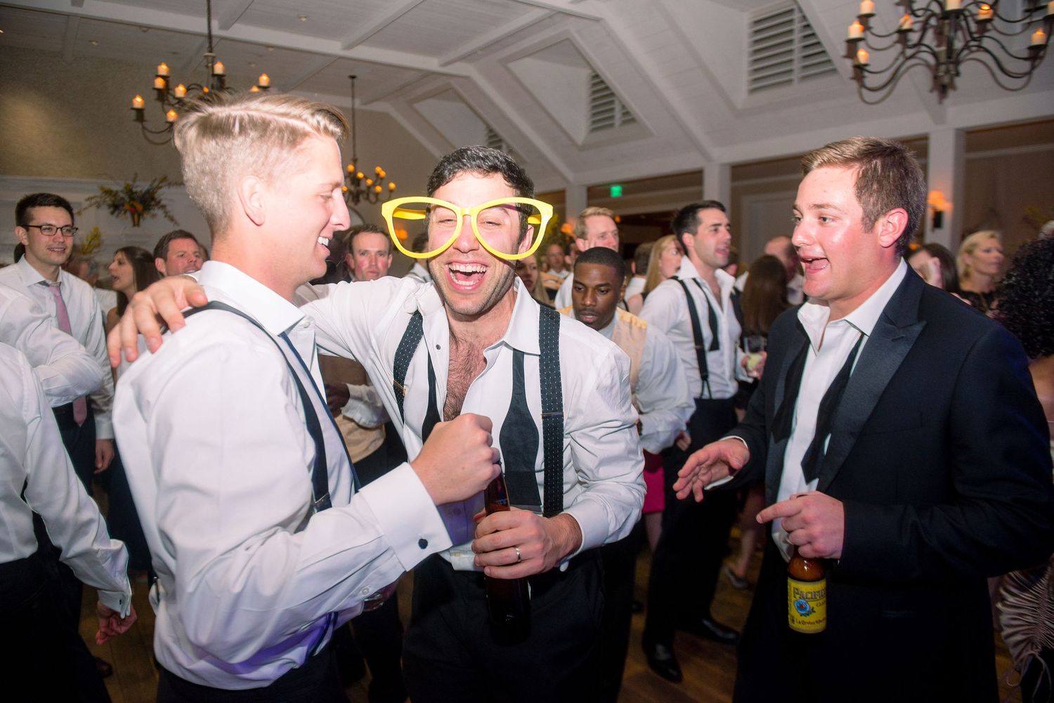 People in white dress shirts dancing and celebrating at a lively party event.