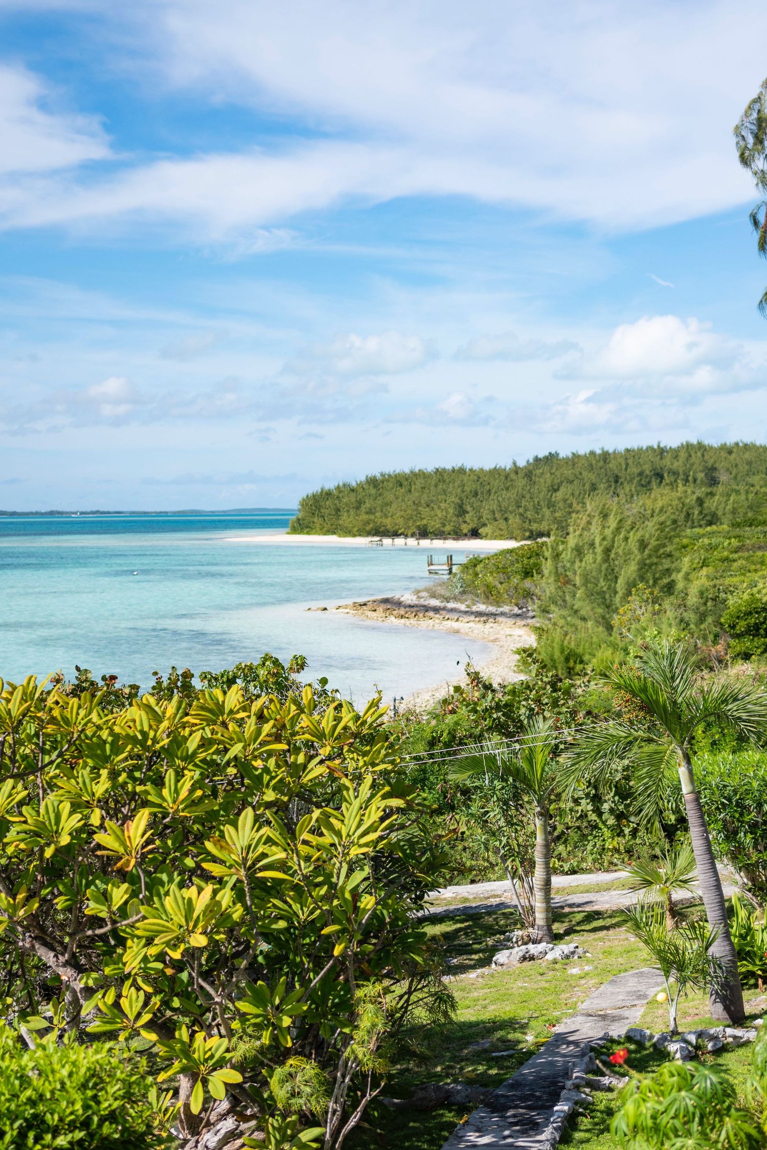 Tropical beach paradise with turquoise waters, white sand, and lush green vegetation along the coastline.