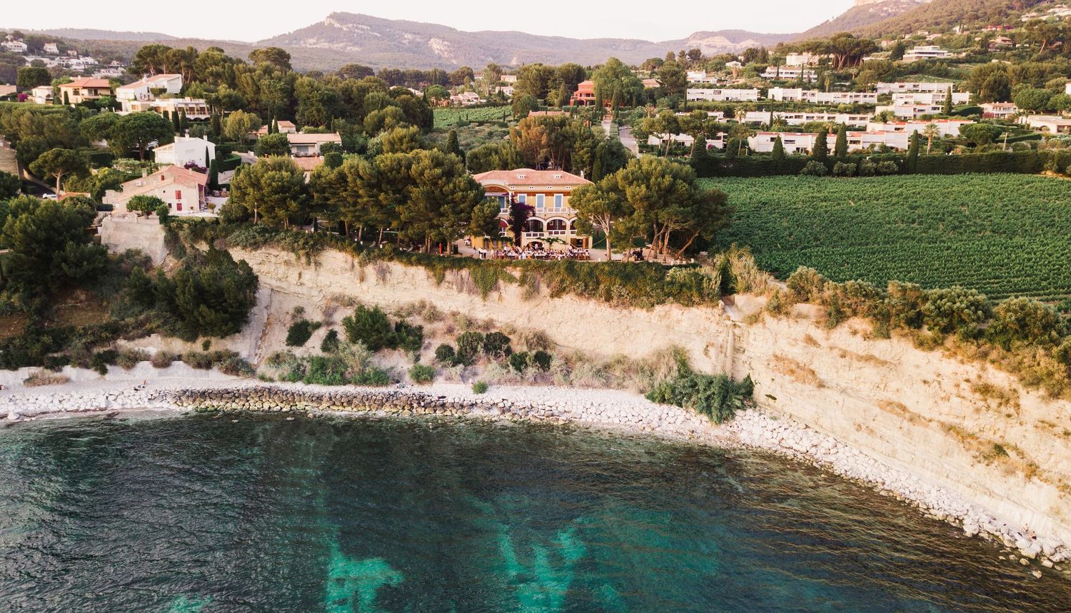 Coastal aerial view of Mediterranean shoreline of Cassis France with sandy beaches, cliffs and scattered villas.