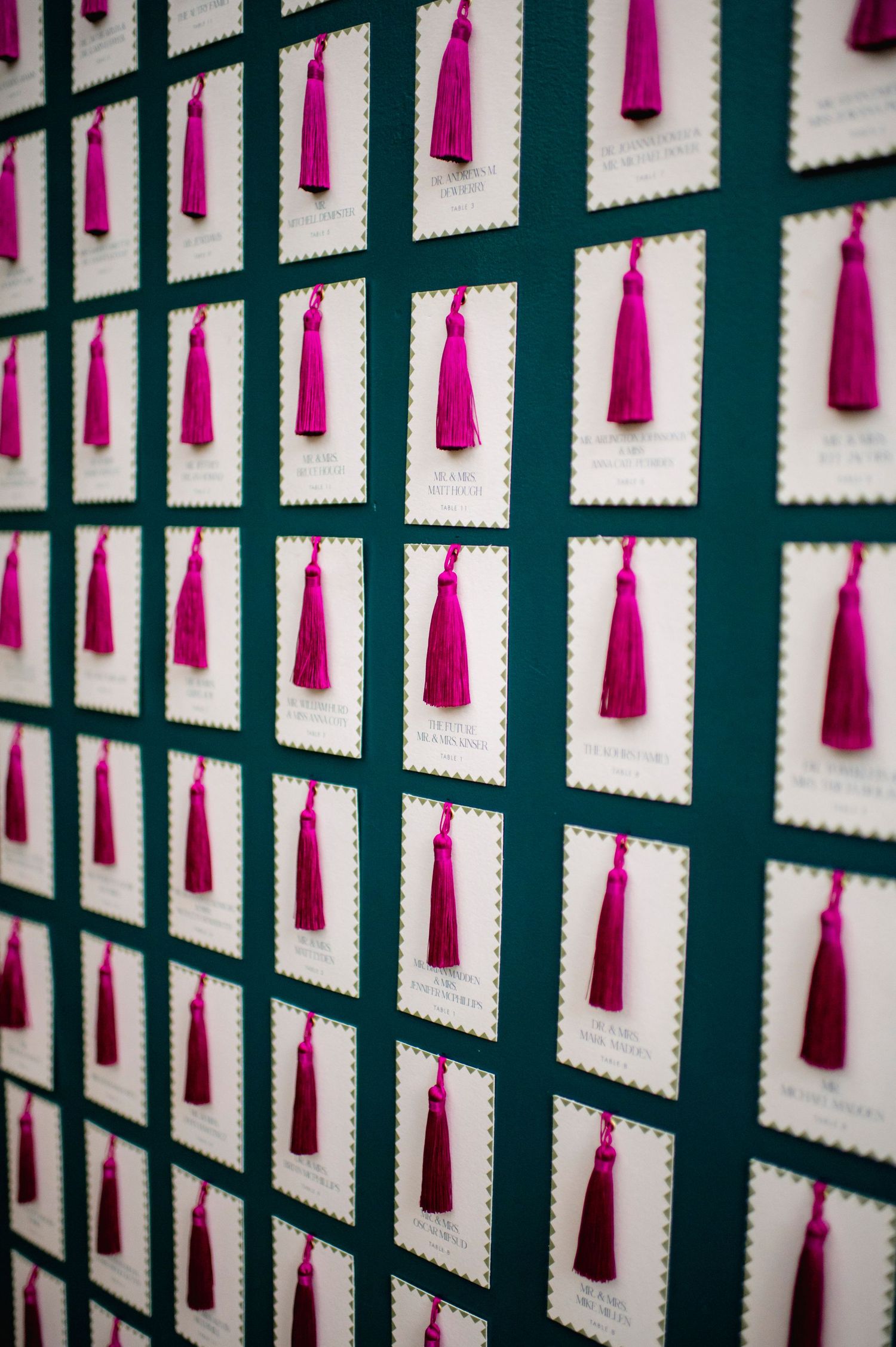 Decorative wall display featuring hanging pink tassels in geometric pattern.