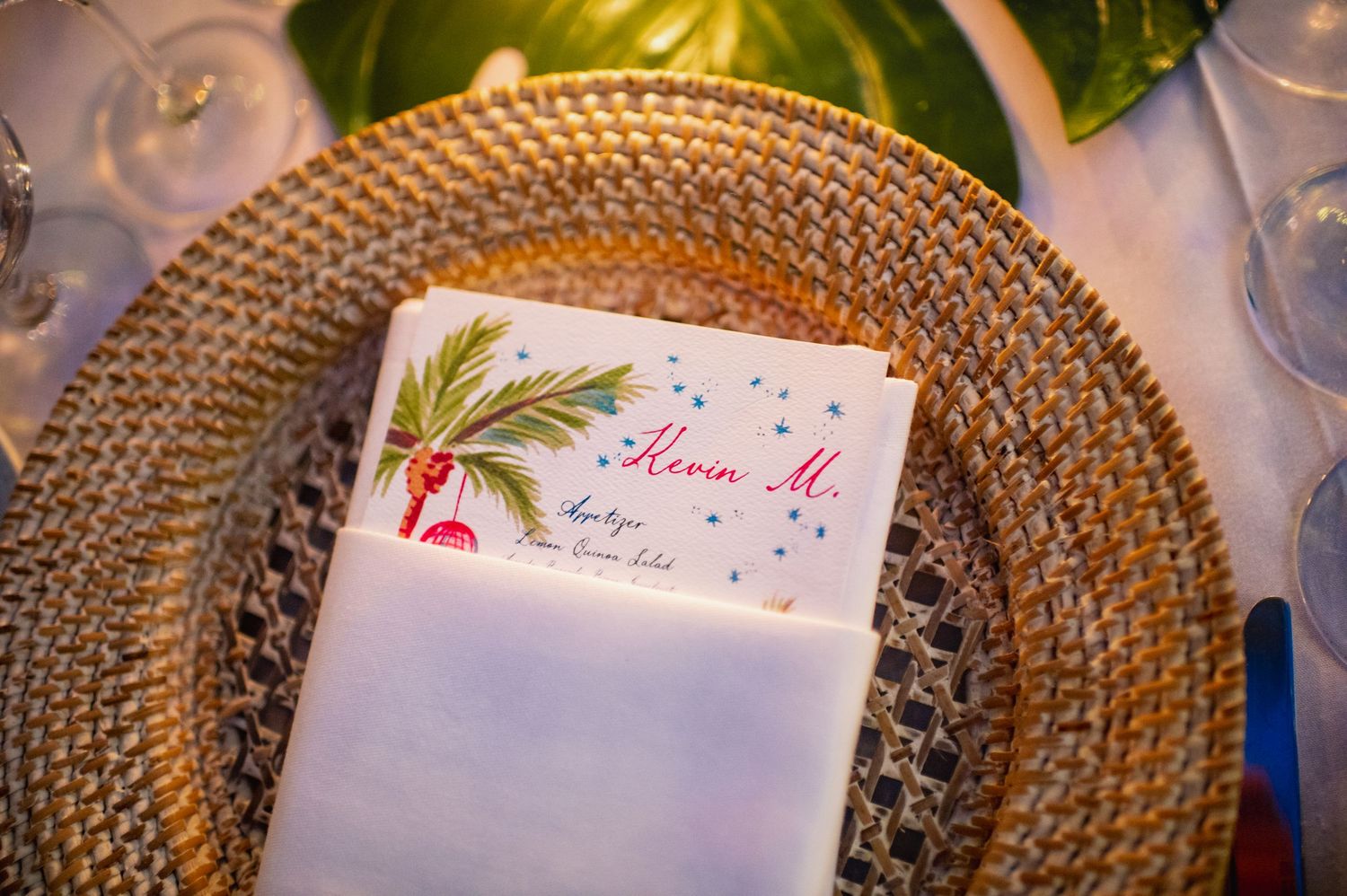 Elegant place setting with decorative charger plate and floral menu card at wedding reception.