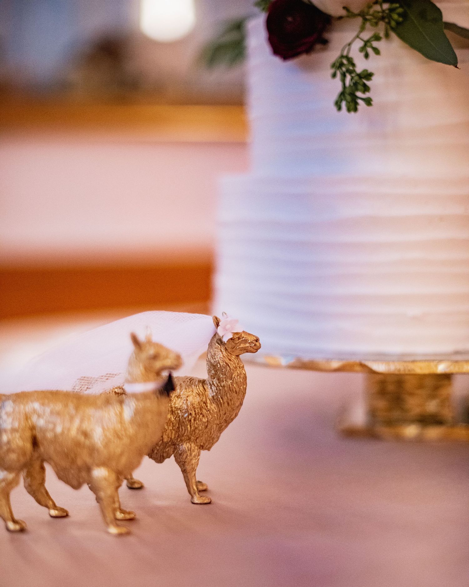 Small golden lion figurines lined up in a row on a reflective surface with soft lighting.