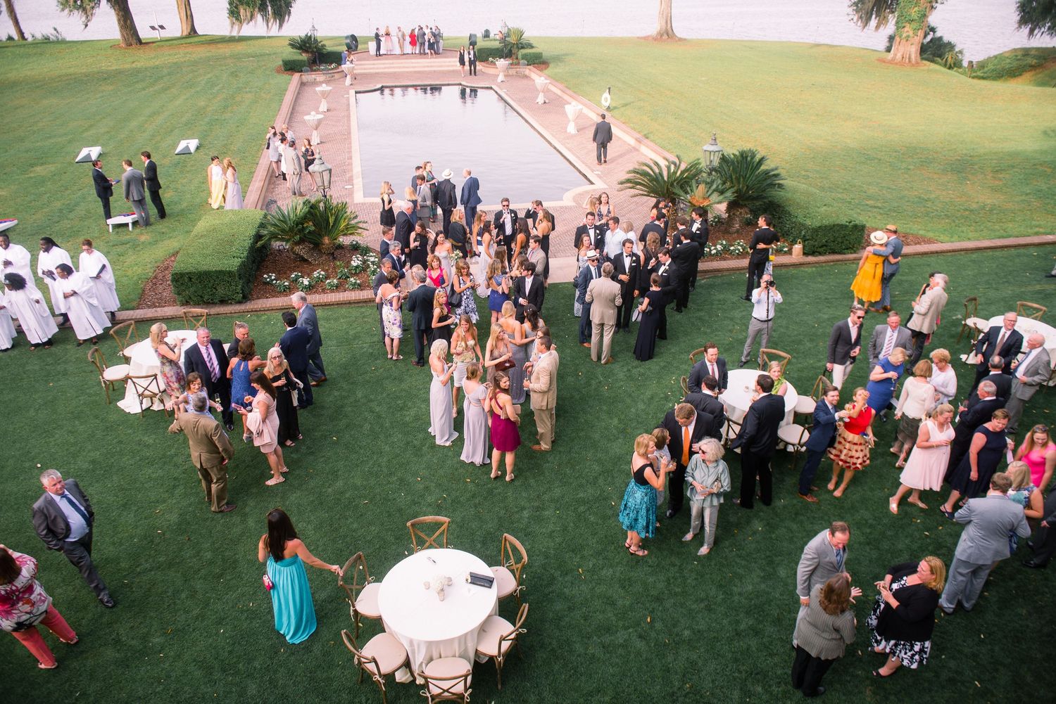 Wedding guests gather on a green lawn during an outdoor summer ceremony with multiple candid group shots.