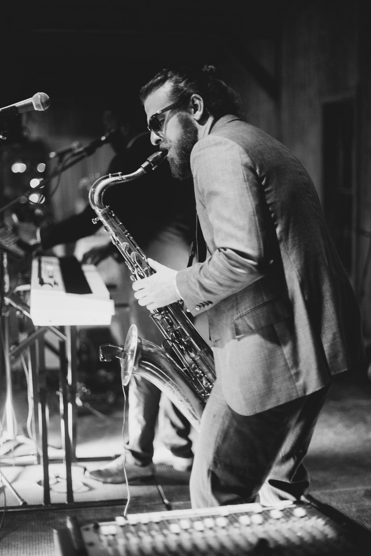 Black and white photos show musicians performing on stage with saxophones and other instruments in a jazz concert setting.
