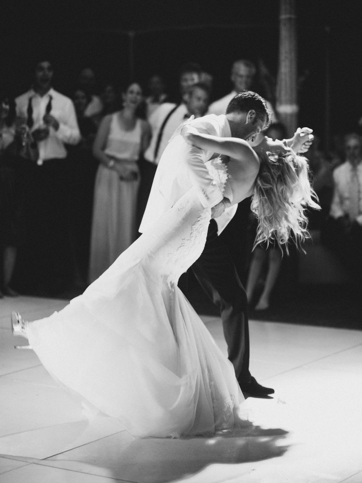 A graceful sequence of ballroom dancers in flowing white dresses performing elegant spins on a dance floor.