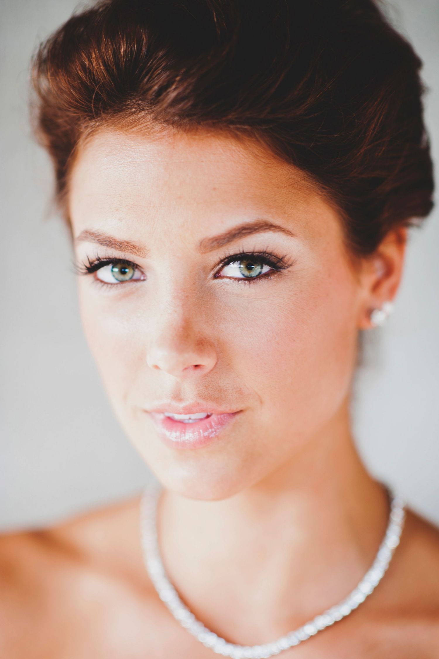 Close-up beauty shots showcasing elegant bridal makeup and pearl necklace details.