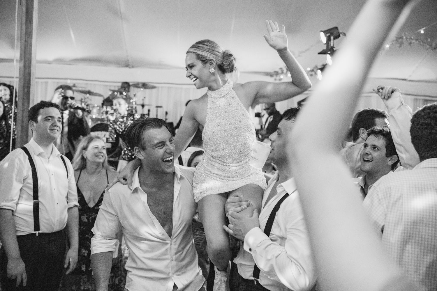 Black and white photo of wedding guests dancing and celebrating on the dance floor.