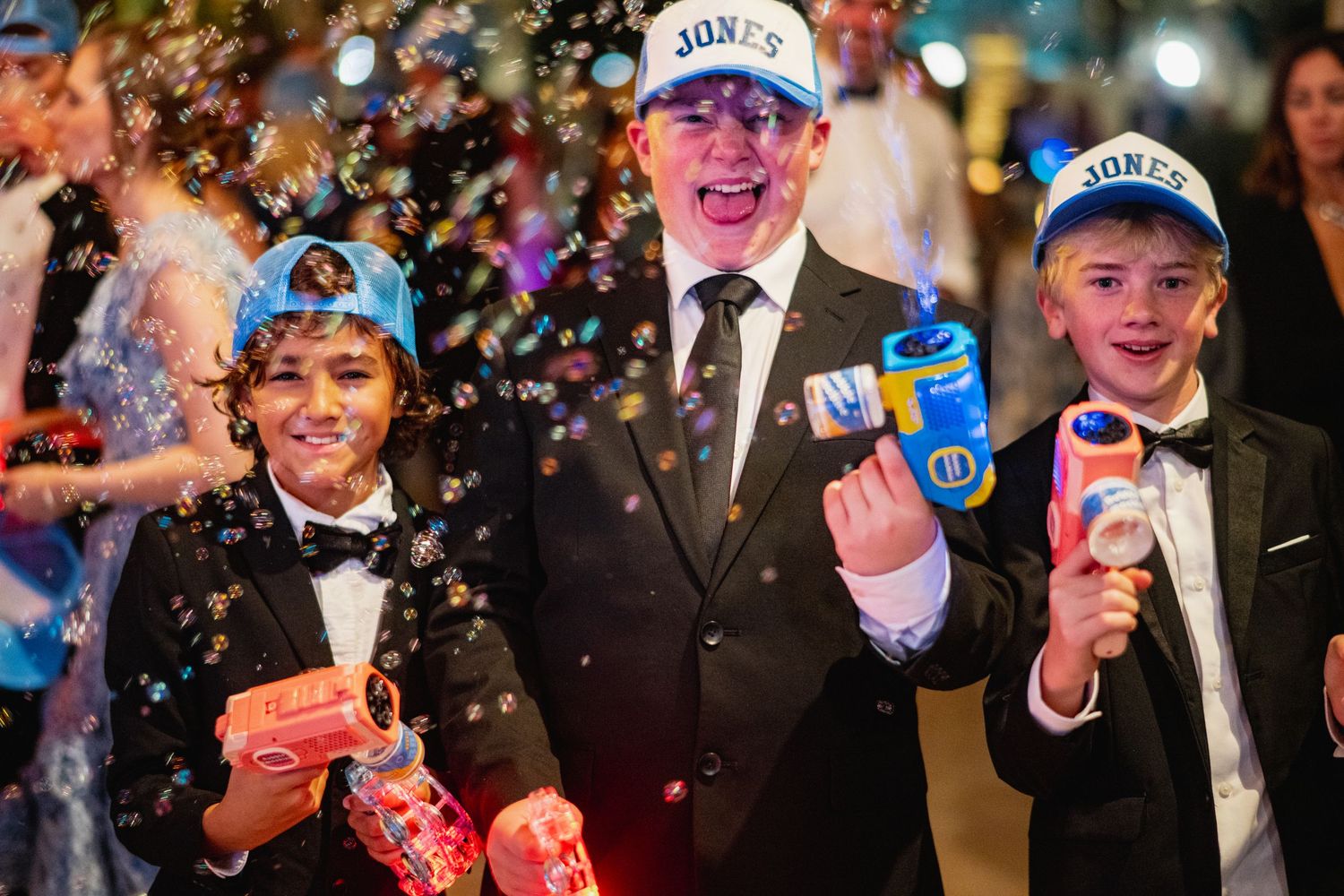A group of people celebrating with confetti and champagne at what appears to be a formal event or party.