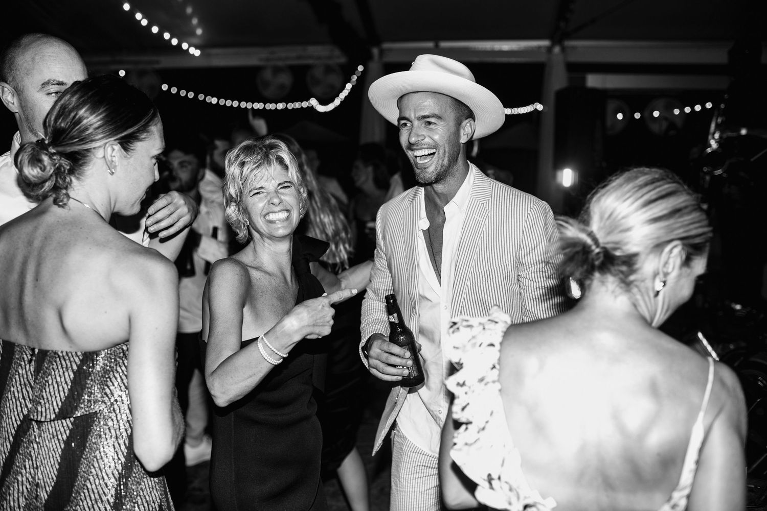 A black and white photo montage showing candid party moments with people dancing and celebrating at a festive event.
