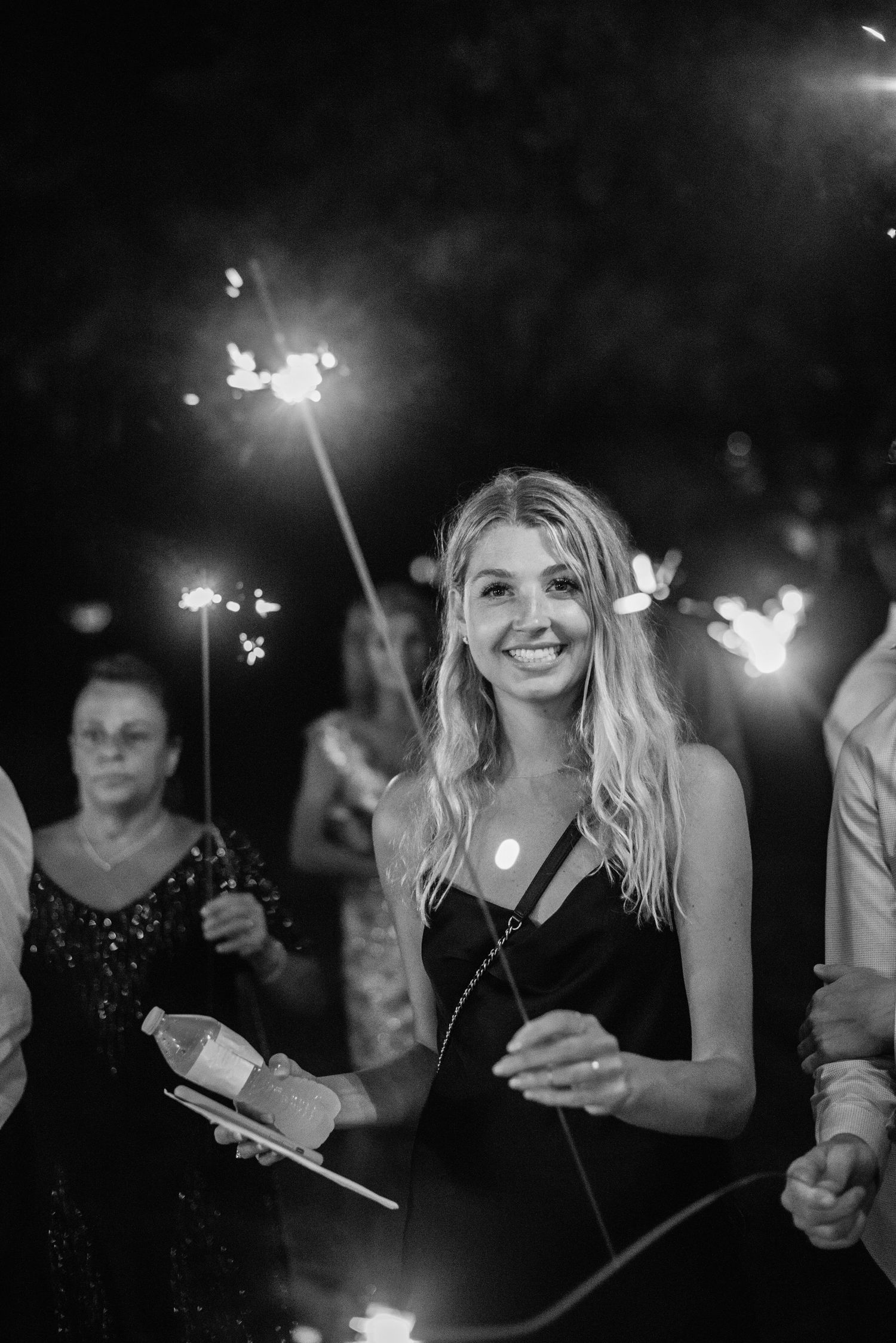 A group of people holding sparklers at night creating a magical atmosphere with glowing lights.