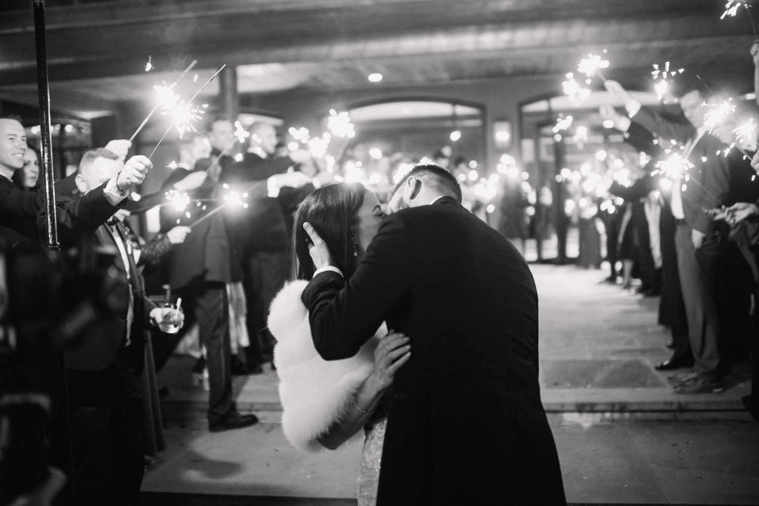 A series of black and white street photographs showing people walking at night with illuminated lights in an urban setting.