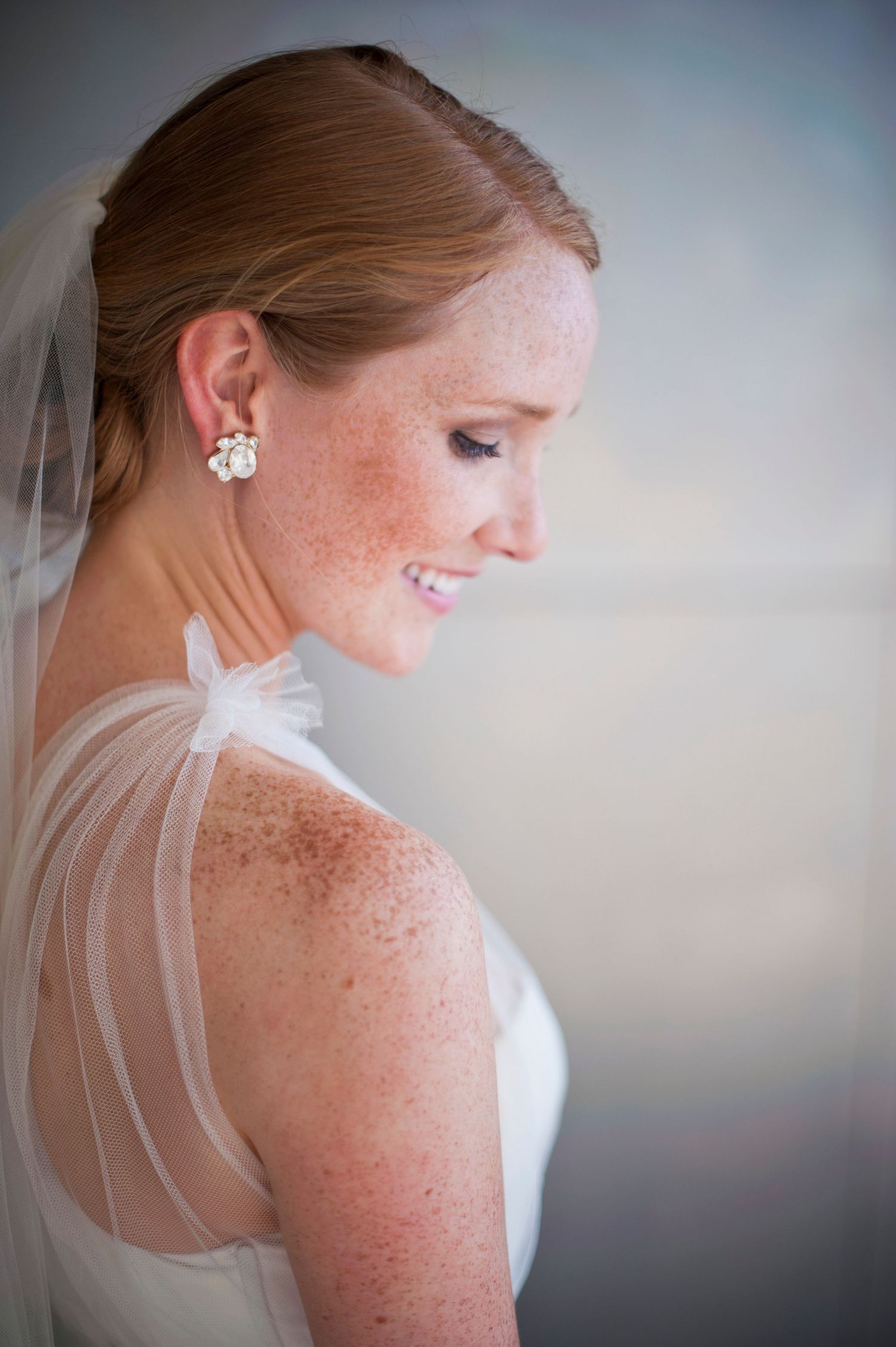 Elegant bridal portraits showcasing delicate lace details and veil against soft background.