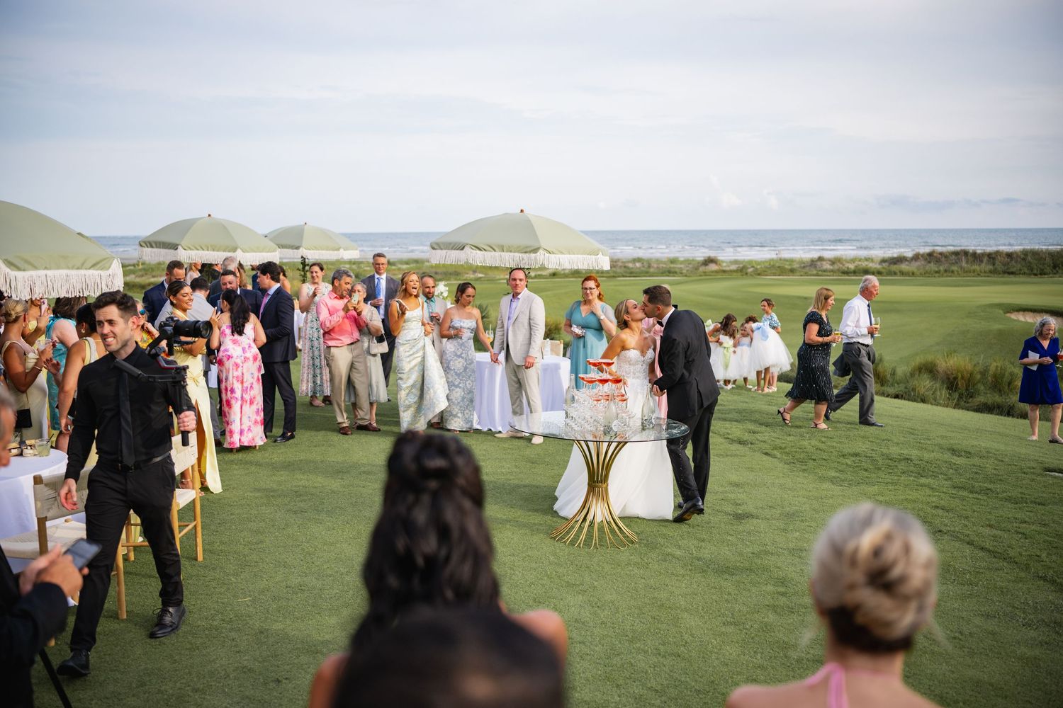 Outdoor wedding ceremony on a scenic golf course with mountains and water in the background.