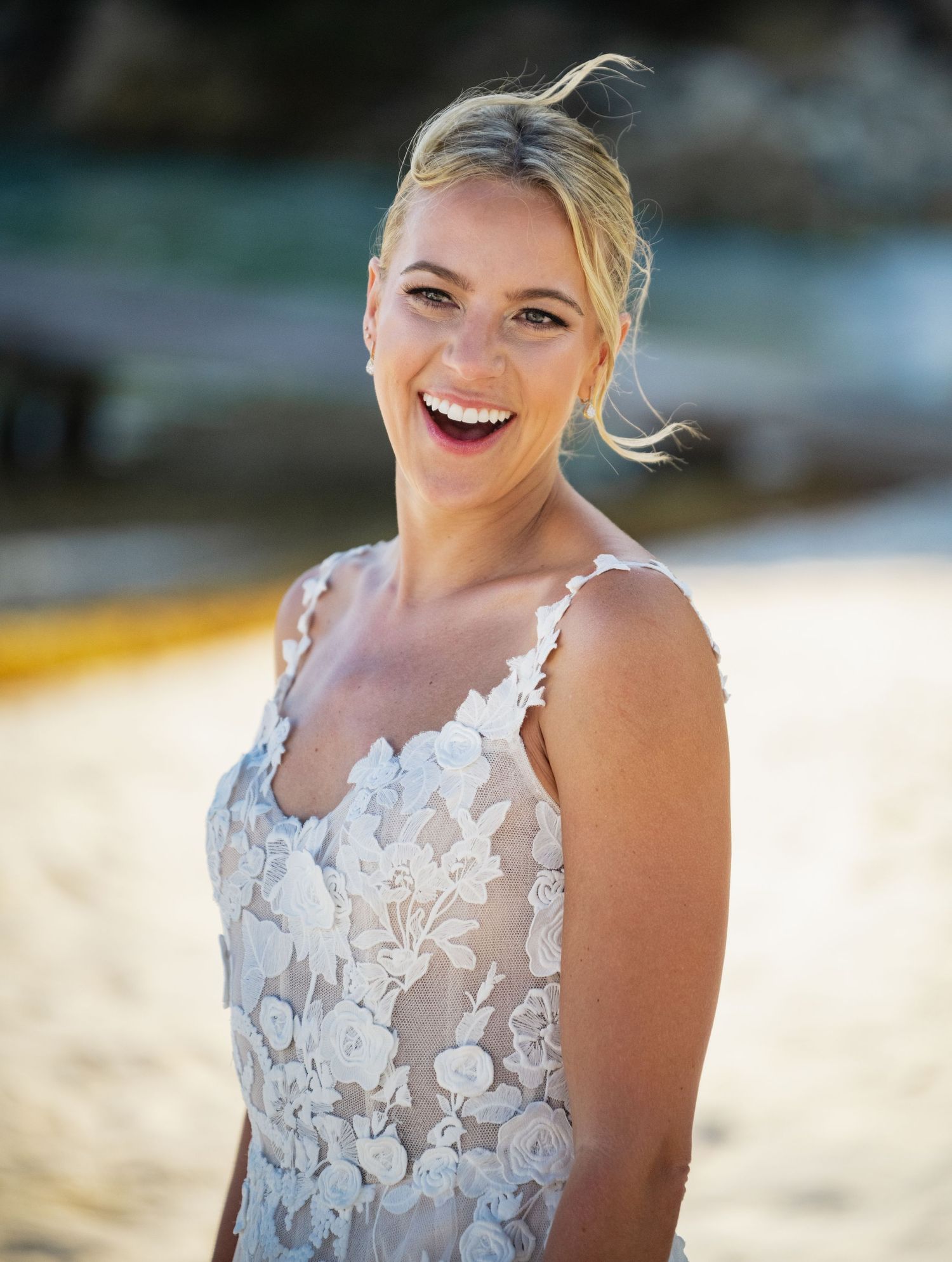 Close-up portraits of a bride wearing a delicate lace wedding dress on a sunny beach.