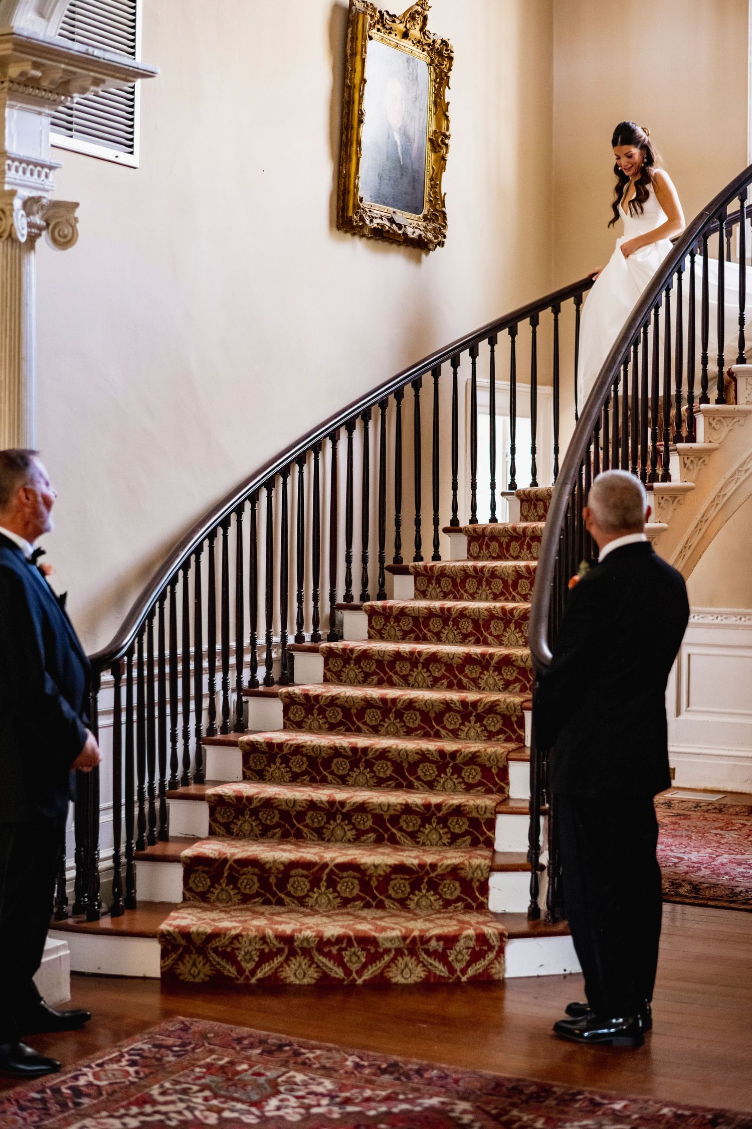 A series of photos showing two people in suits walking up an elegant staircase with ornate carpeting and dark railings.