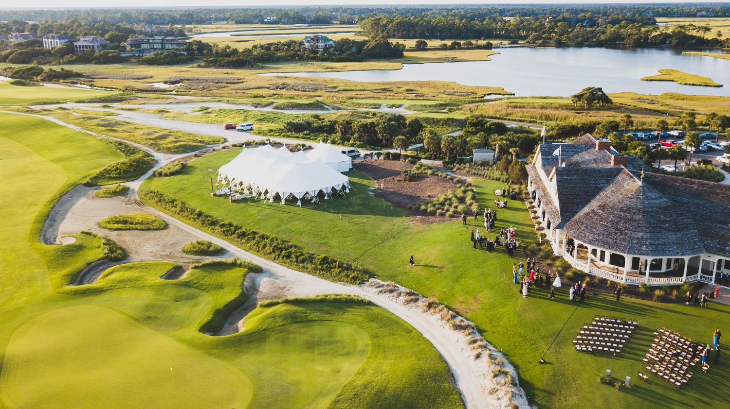 Aerial panoramic view of a scenic golf course with lush greens, sand traps, and clubhouse facilities.