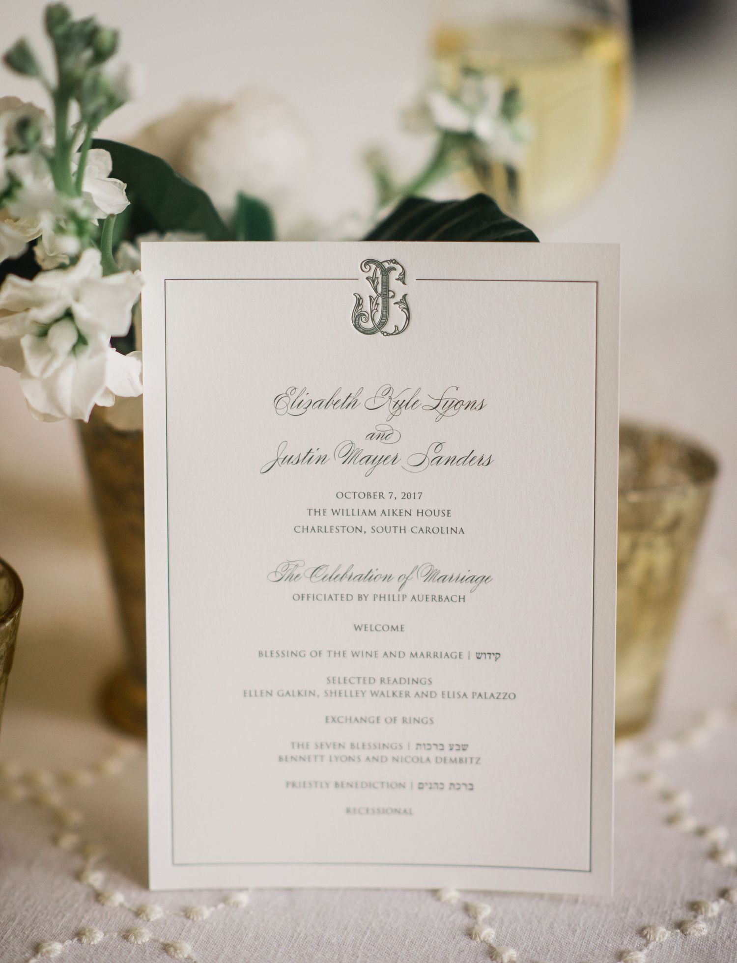 Elegant white wedding invitation cards displayed with delicate floral decorations and pearl accents.